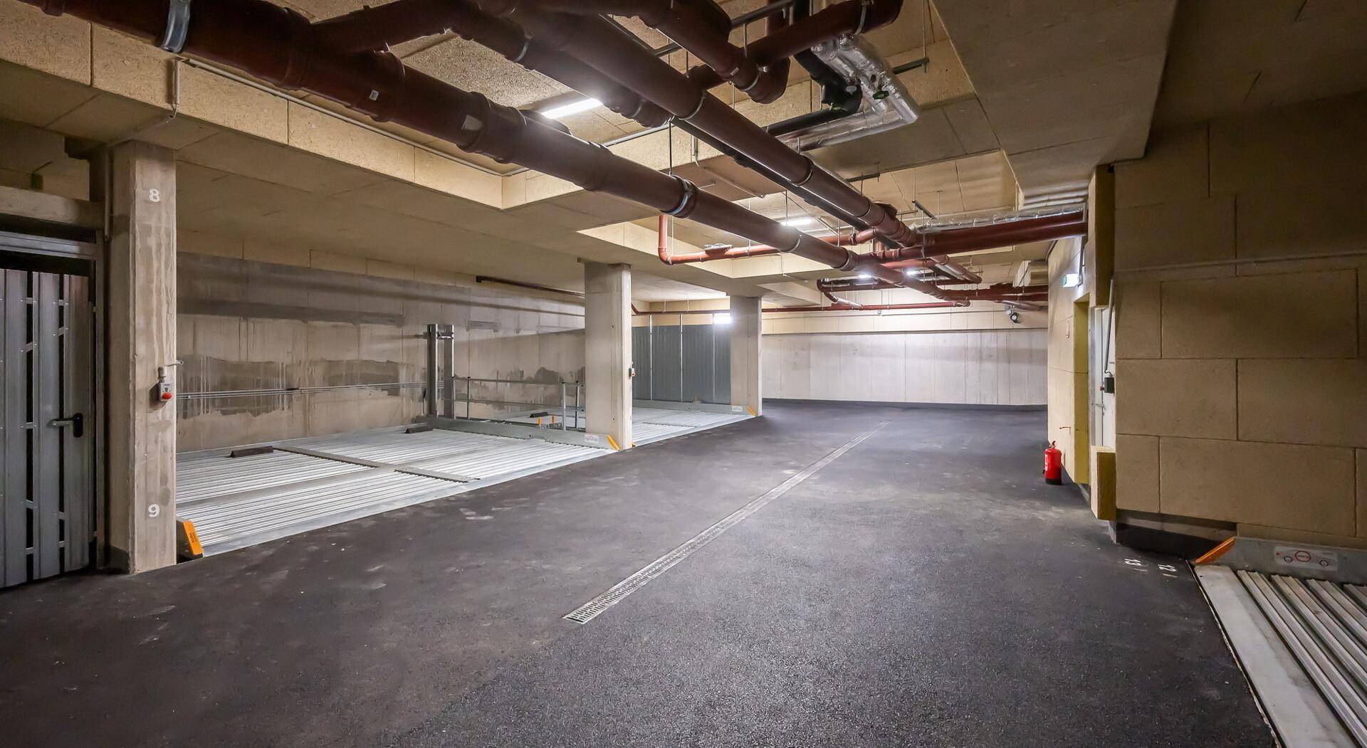 Tiefgarage mit mehreren Stellplätzen und moderner Beleuchtung.