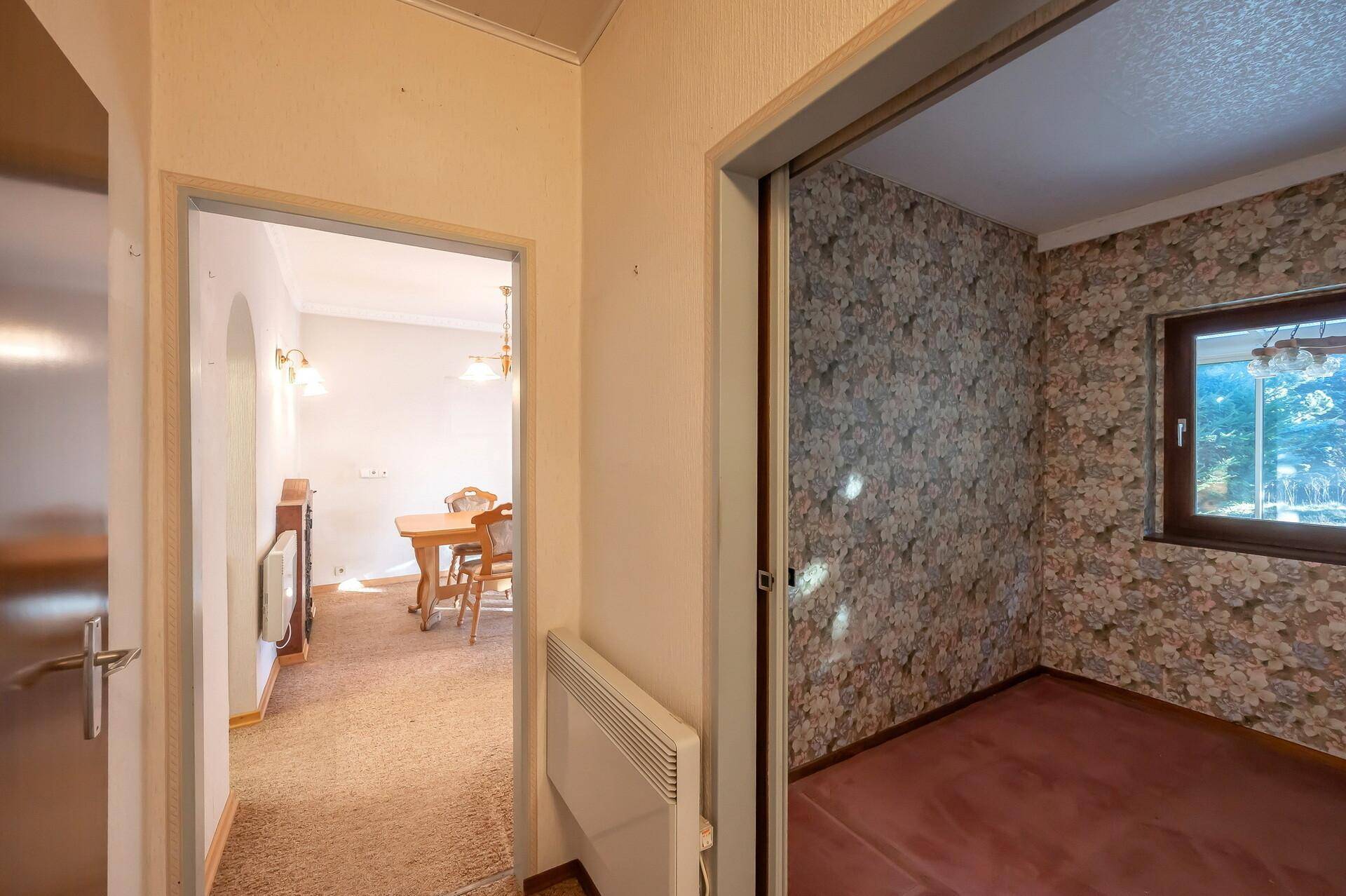 Flur mit Teppichboden, der zum Esszimmer und einem weiteren Zimmer führt.