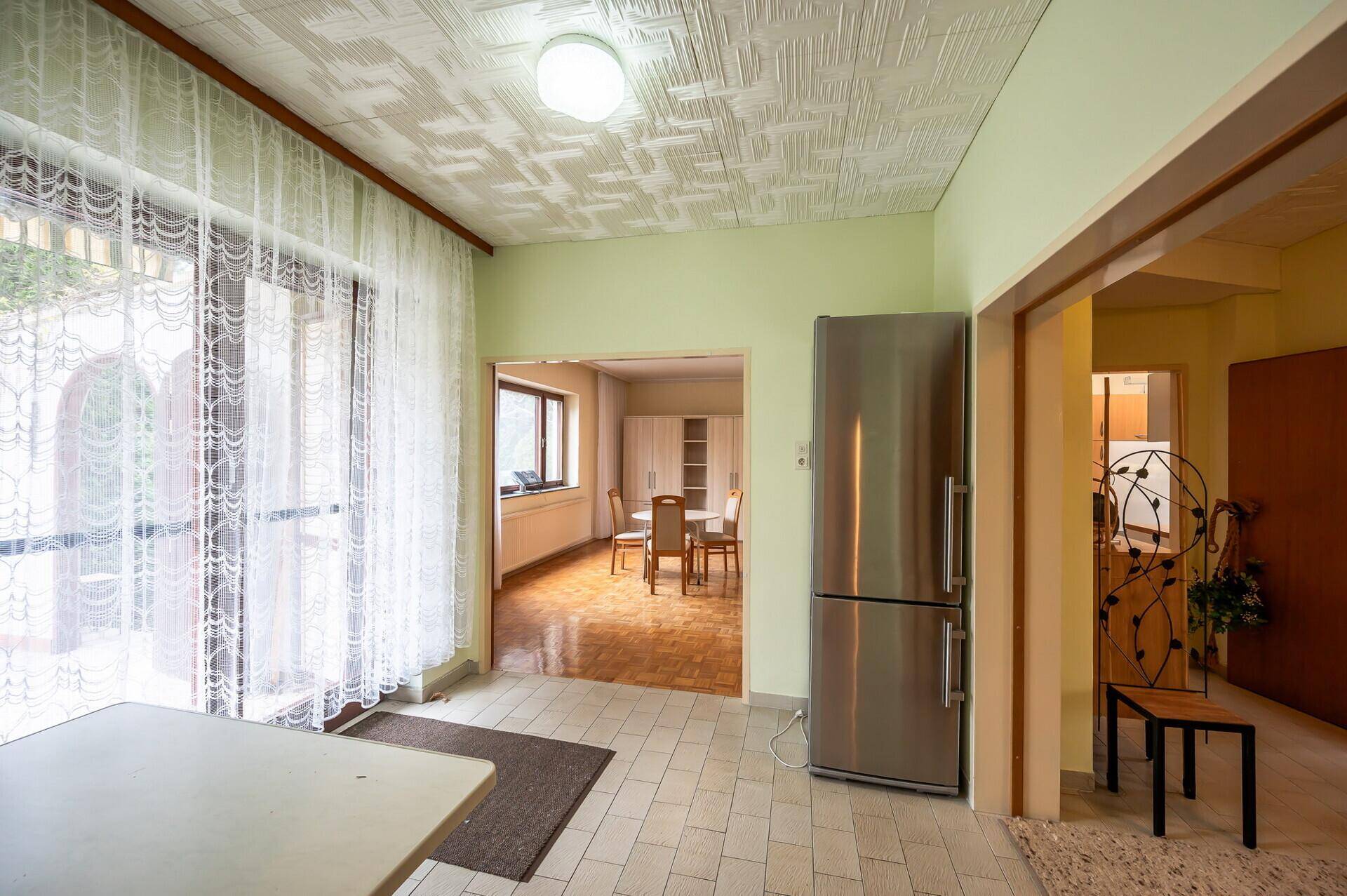 Übergangsbereich mit Fliesenboden, großem Kühlschrank und Zugang zum Essbereich.