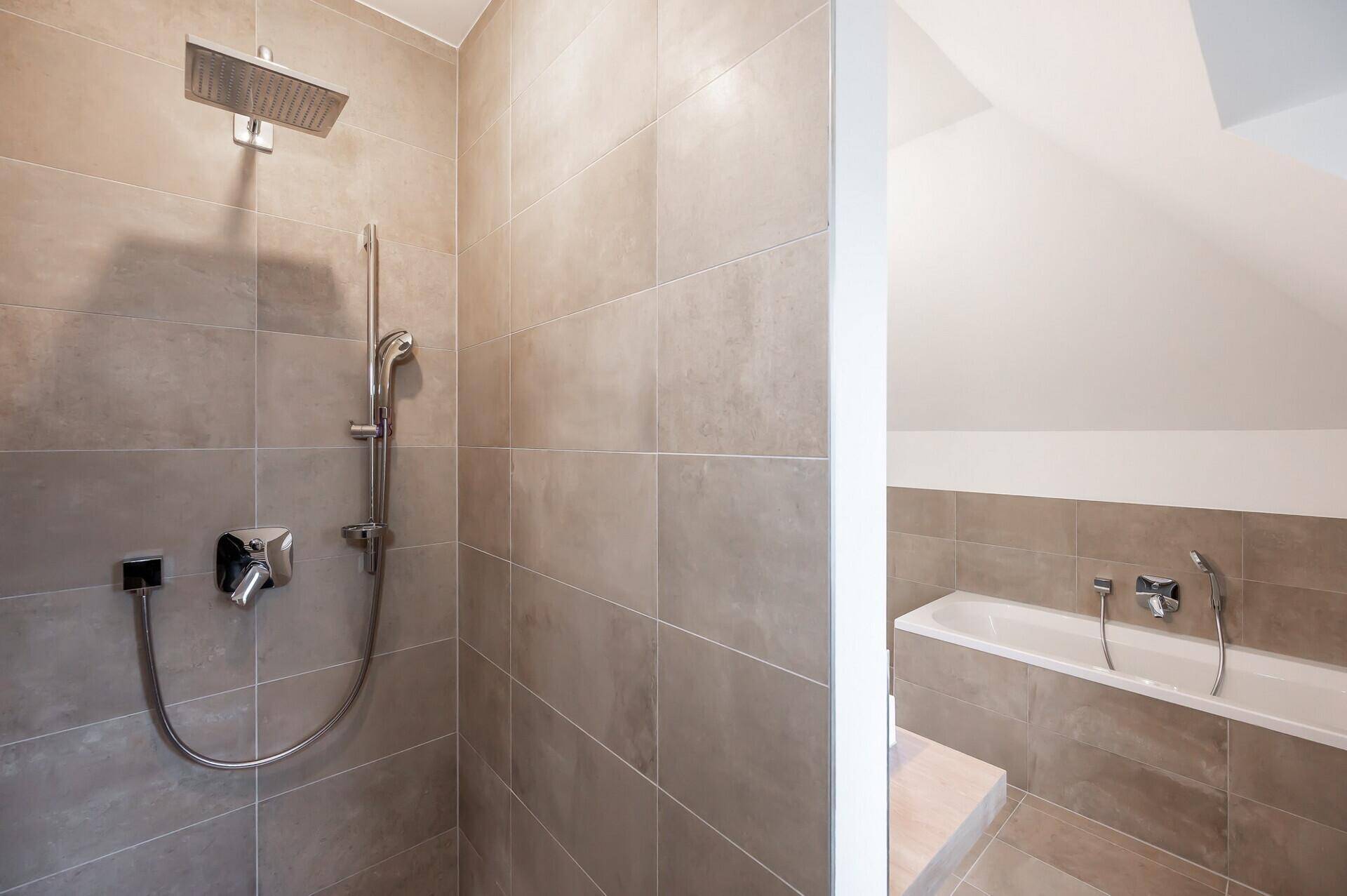 Moderne Dusche mit Regenduschkopf und Badewanne in einem hellen Badezimmer.