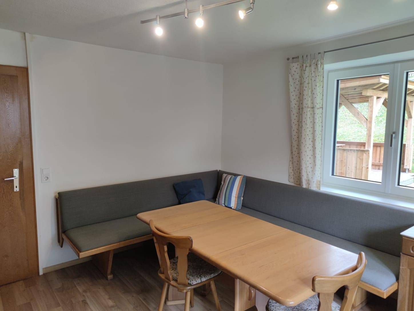 Gemütlicher Essbereich mit Eckbank und Holztisch, ideal für gemeinsame Mahlzeiten am Fenster.