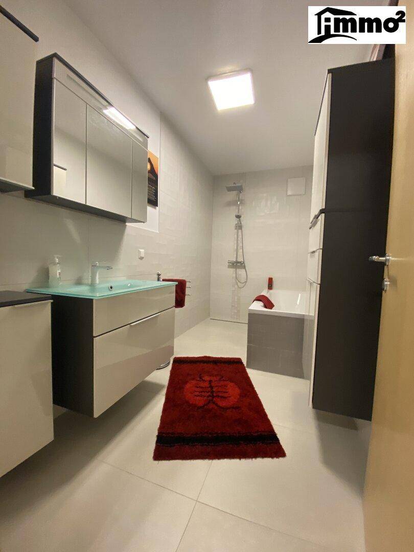 Modernes Badezimmer mit Badewanne, Dusche, Einzelwaschbecken und Spiegelschrank.