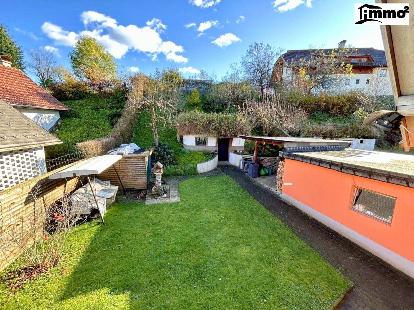 Großer Gartenbereich mit Rasenfläche, Bäumen und einem kleinen Gartenhaus.