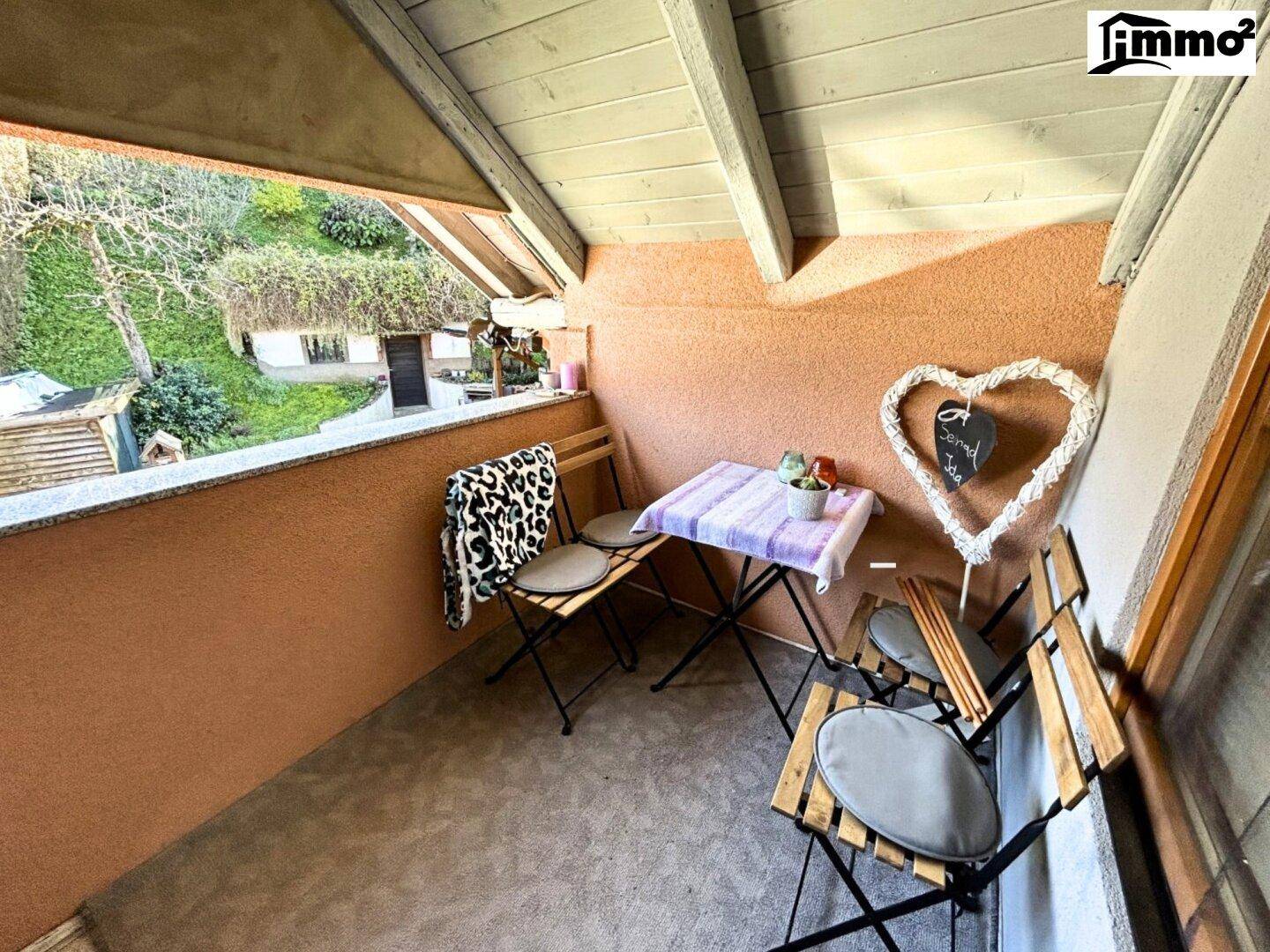 Gemütlicher Balkon mit Sitzgelegenheiten und Blick auf den Gartenbereich.