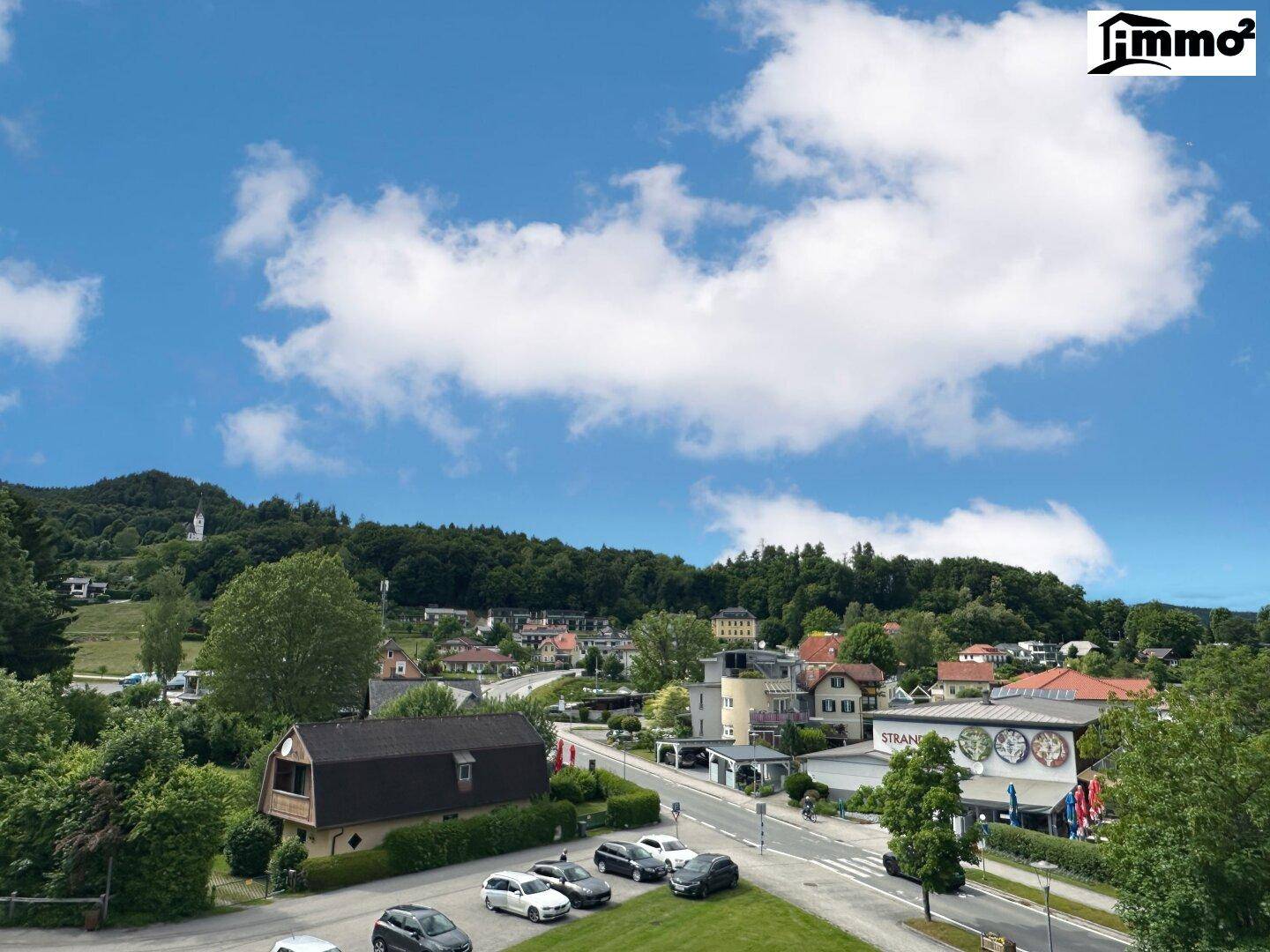 Weitläufiger Blick über die umliegende Wohngegend mit viel Grün und blauem Himmel.