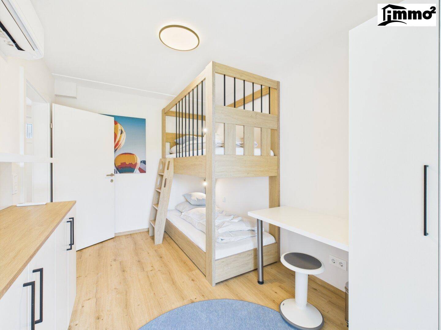 Helles Schlafzimmer mit modernem Etagenbett, Schreibtisch, weißem Kleiderschrank und hellem Holzfußboden.