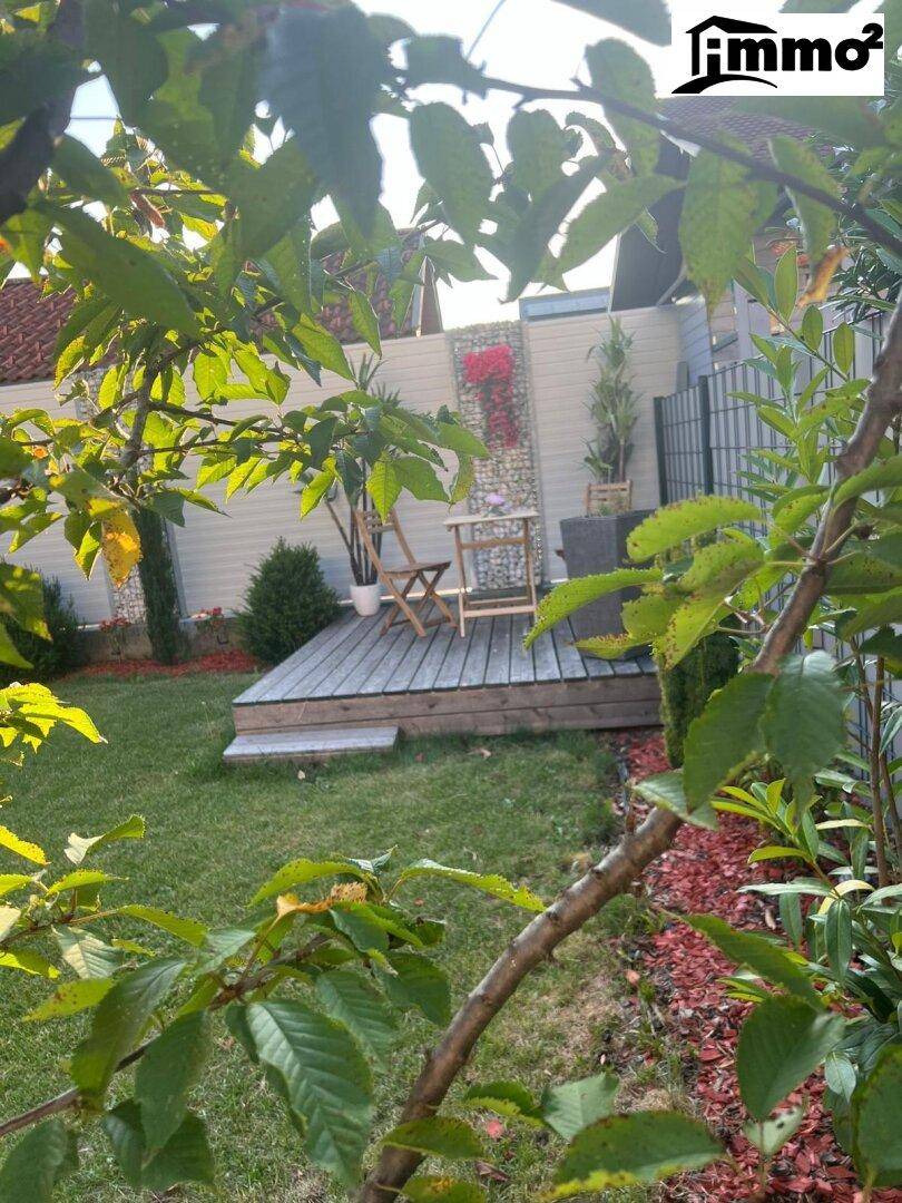 Gepflegter Garten mit Rasenfläche, Holzterrasse und modernem Sichtschutz.