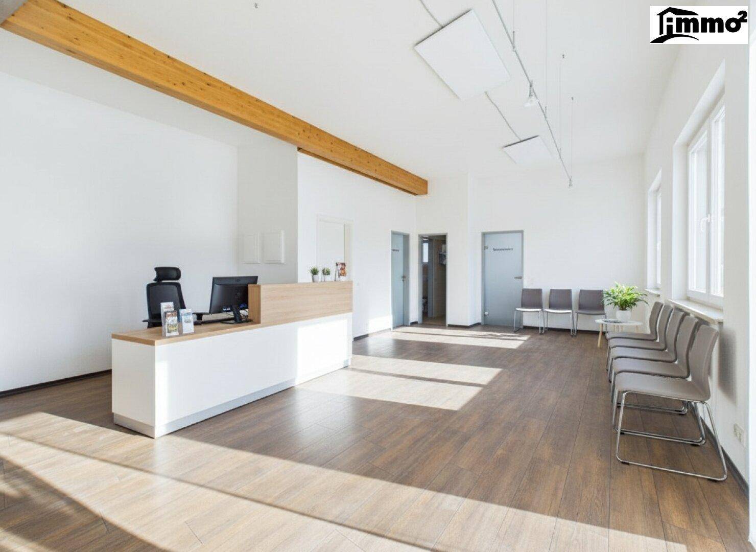 Funktionaler Empfangsbereich mit einer Theke, Bürostühlen und einer Reihe von Warteplätzen.