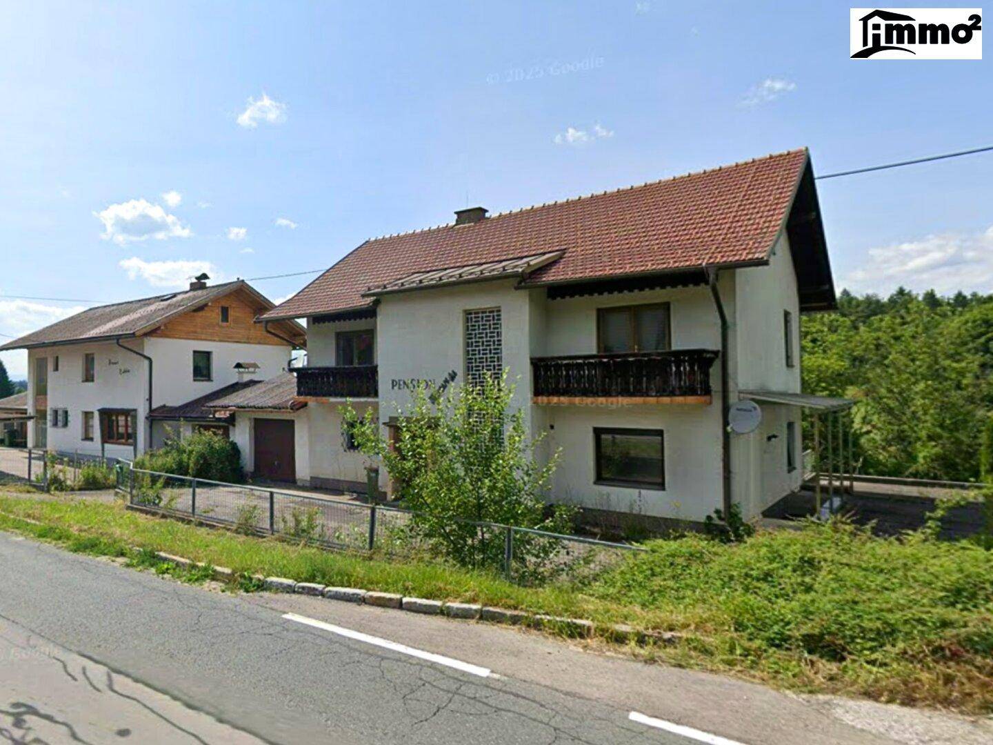 Älteres Gebäude mit traditionellem Satteldach, Balkonen und einer Pension-Beschriftung an der Fassade.
