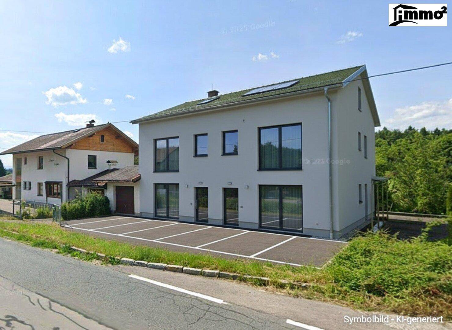Modernisiertes Gebäude mit Flachdach und großen Fenstern, davor mehrere markierte Parkplätze.