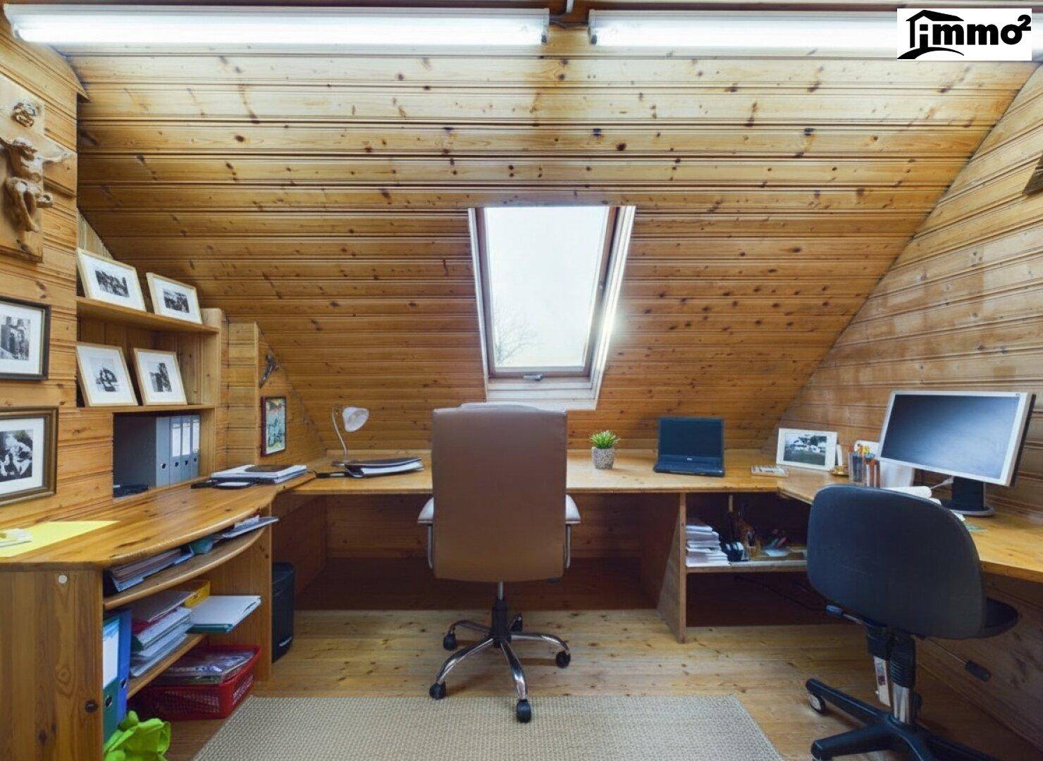 Geräumiges Dachgeschossbüro mit Holzverkleidung, Schreibtischen und Dachfenster für Tageslicht.