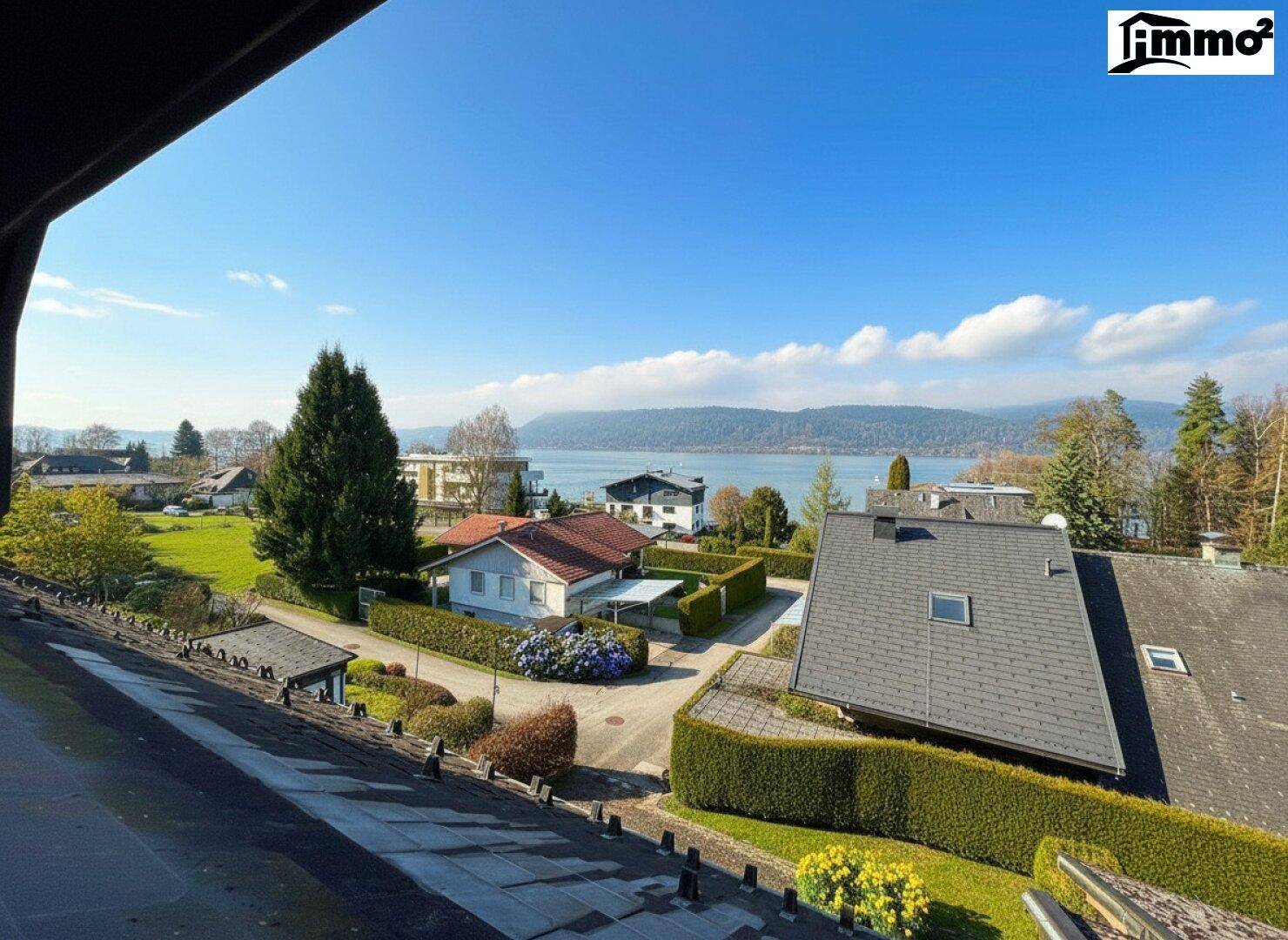 Panoramablick über die umliegende Wohngegend mit See und bewaldeten Hügeln am Horizont.
