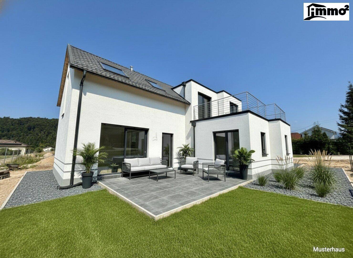 Neubau-Doppelhaushälfte mit moderner Terrasse und pflegeleichtem Gartenbereich unter strahlendem Himmel.