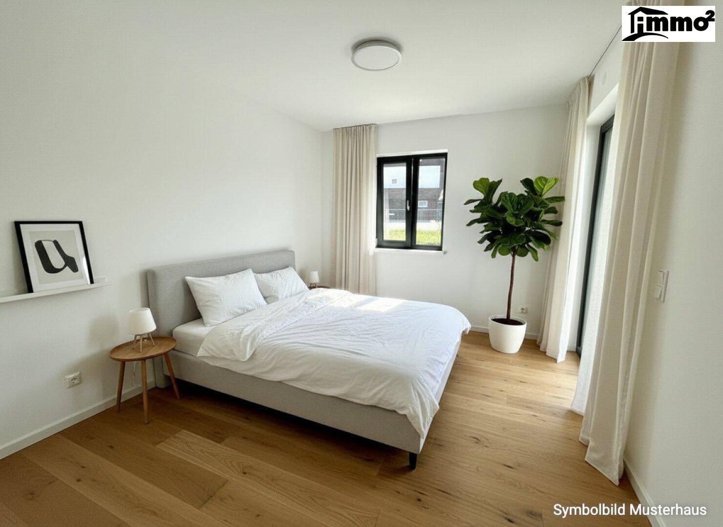 Helles Schlafzimmer mit Holzboden, großem Fenster und Zugang zu einem Balkon oder einer Terrasse.