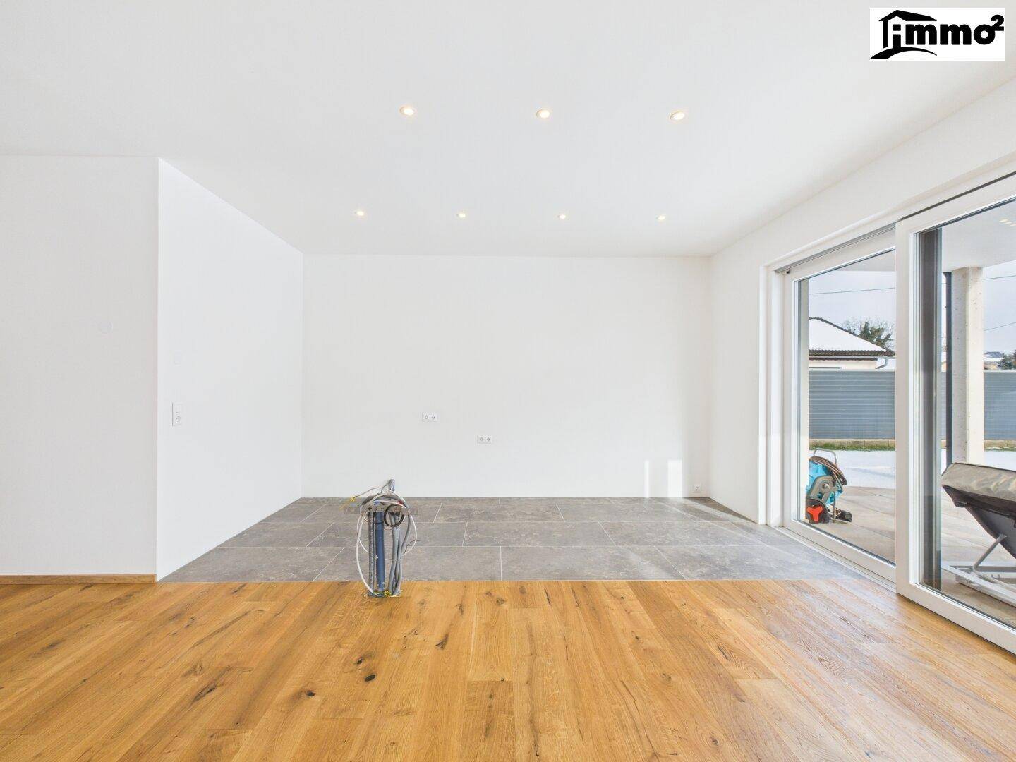 Rohbauküchenbereich mit Fliesenboden und Holzboden, bereit für die Installation der Einbauküche.