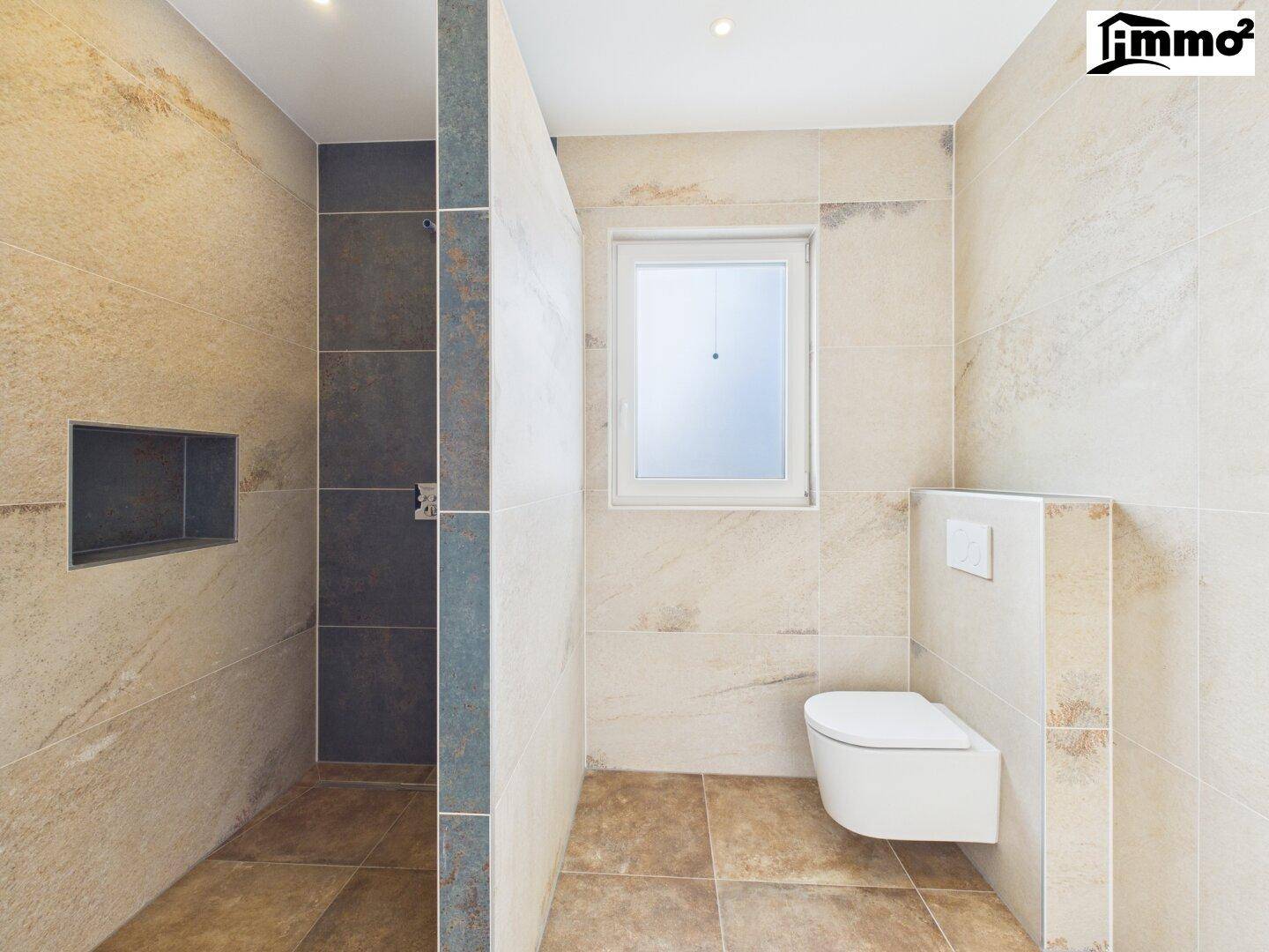 Modernes Badezimmer mit begehbarer Dusche, Wand-WC und beigefarbenen Fliesen.