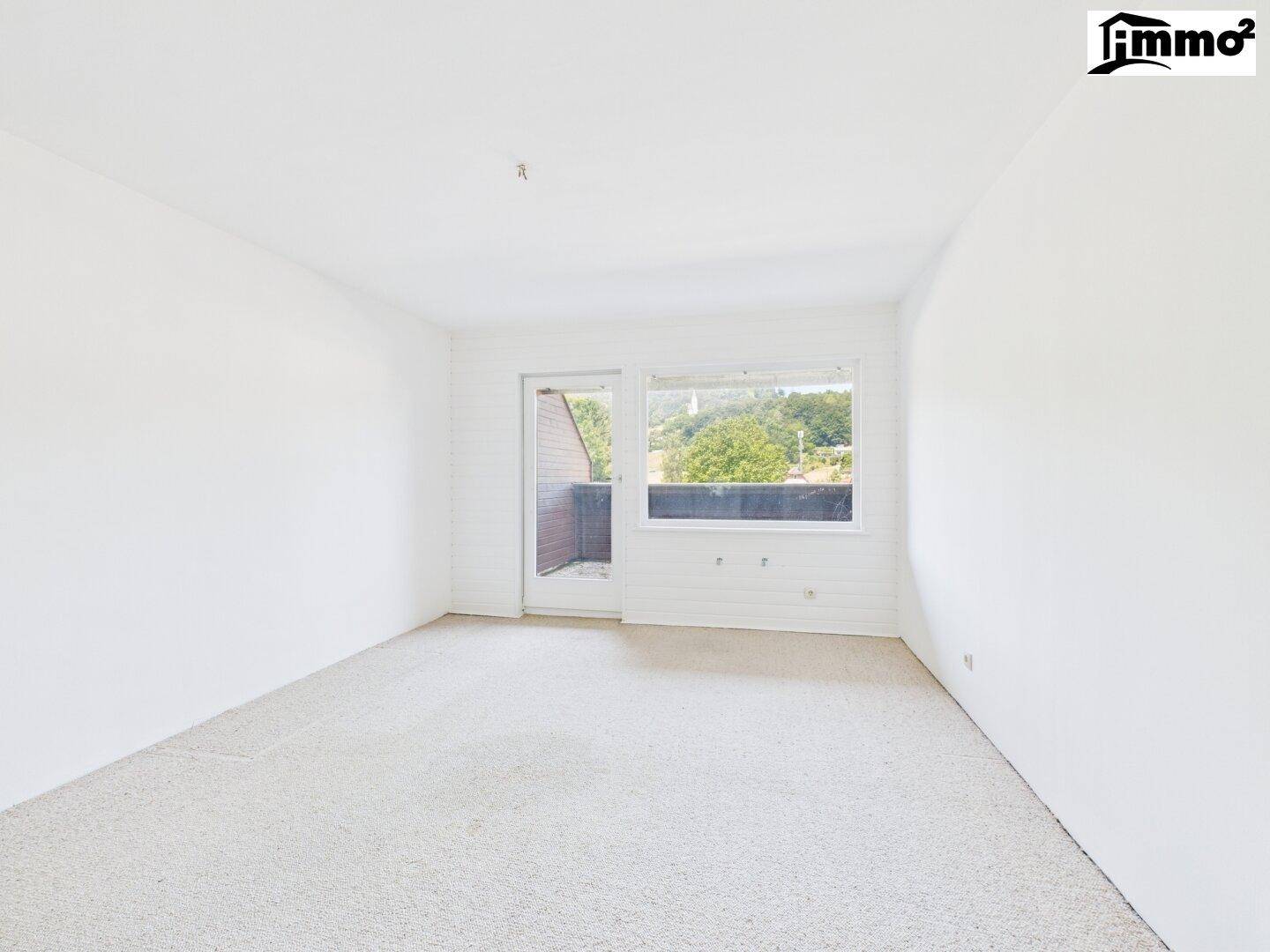 Schlafzimmer mit hellem Teppichboden, großen Fenstern und Zugang zu einem Außenbereich.