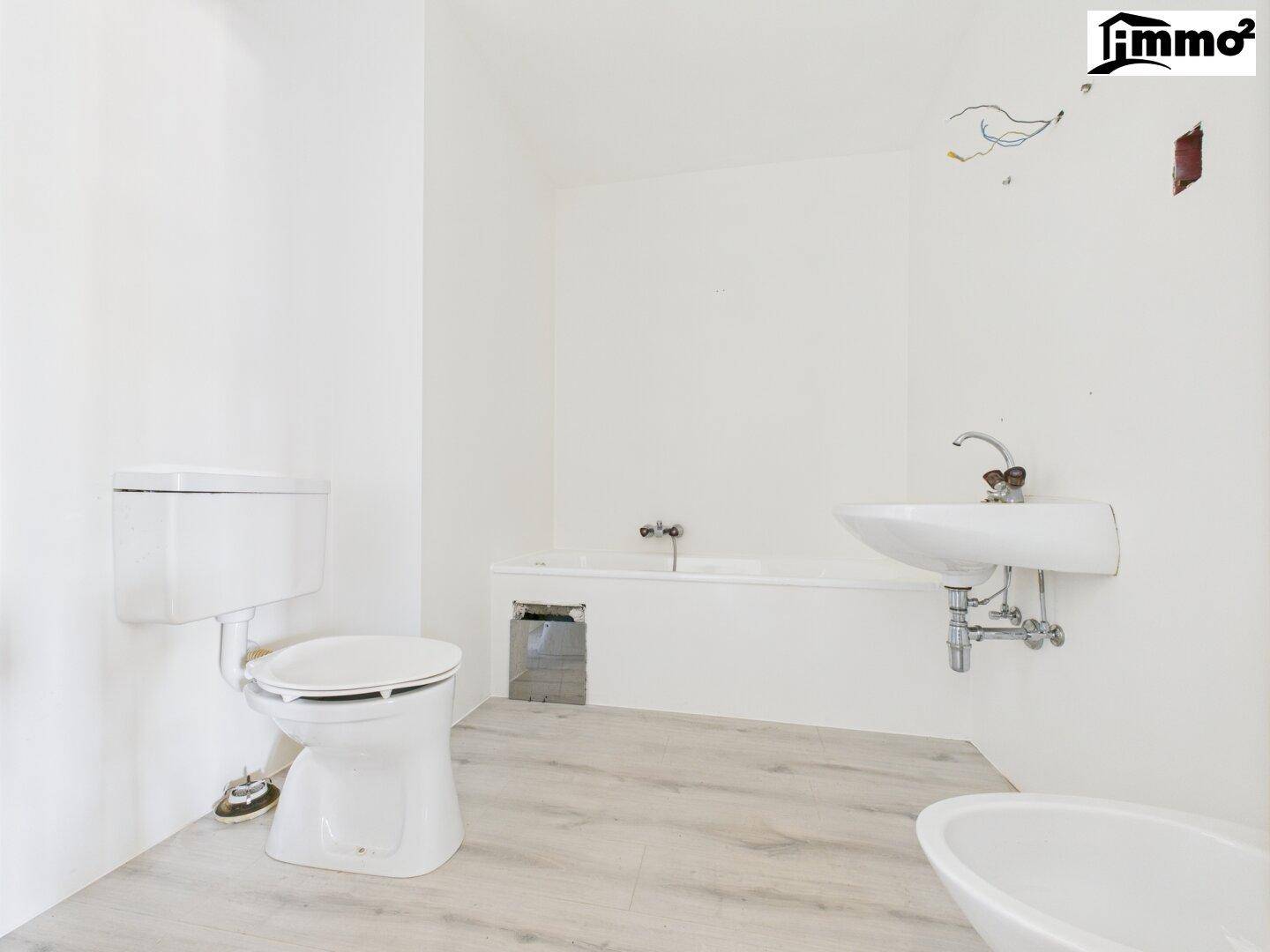 Badezimmer in Renovierung mit Badewanne, WC und Waschbecken, bereit für die Fertigstellung.