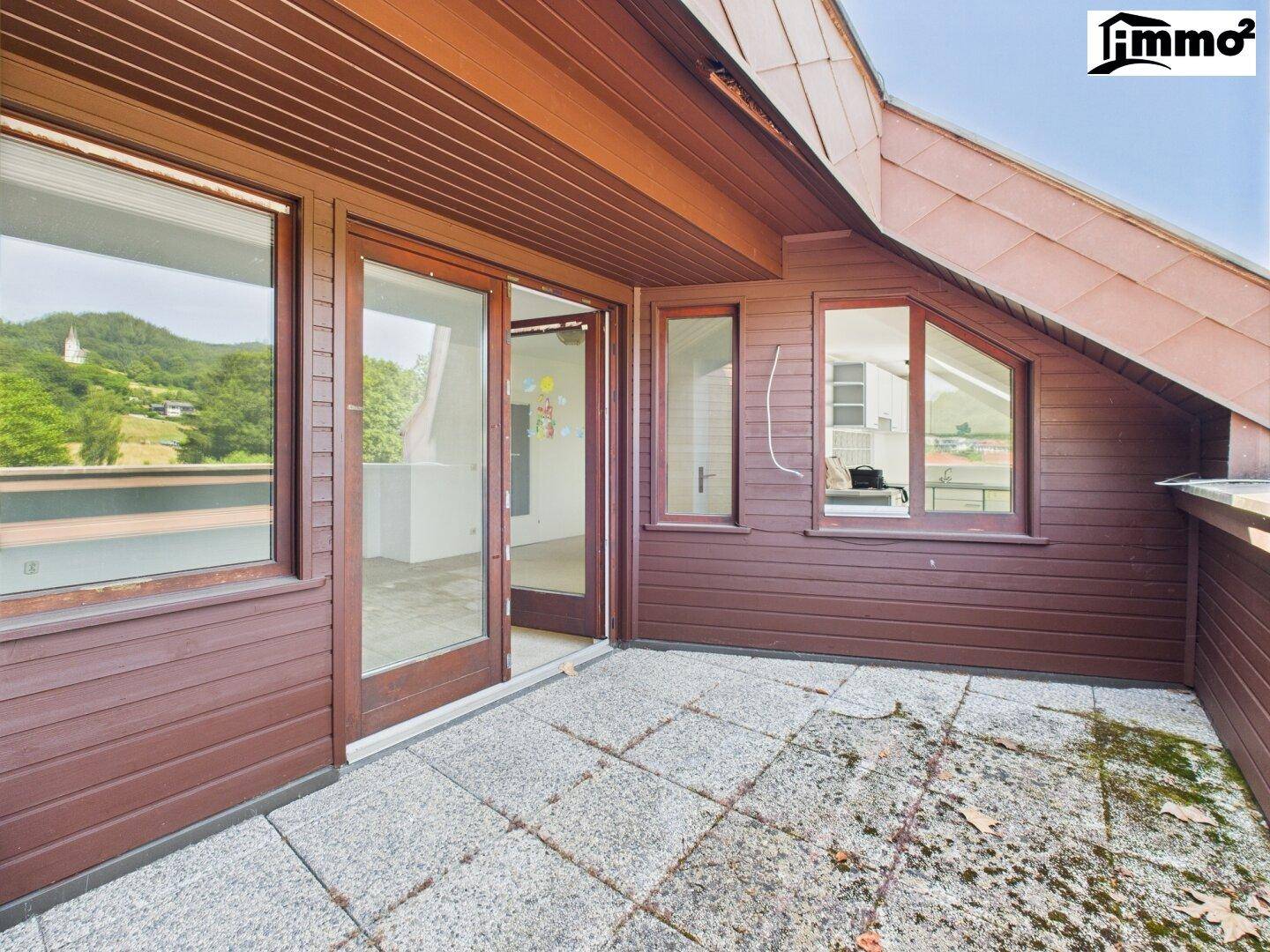 Geräumiger Balkon mit Fliesenboden und Holzverkleidung, ideal für entspannte Stunden im Freien.