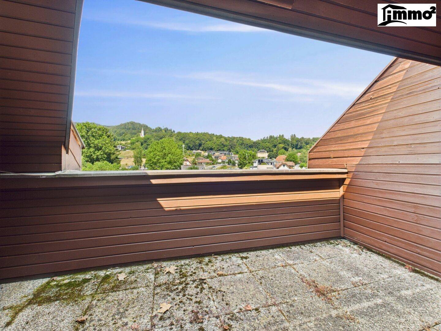 Balkon mit Fliesenboden und Holzverkleidung, bietet einen schönen Blick auf die Umgebung.