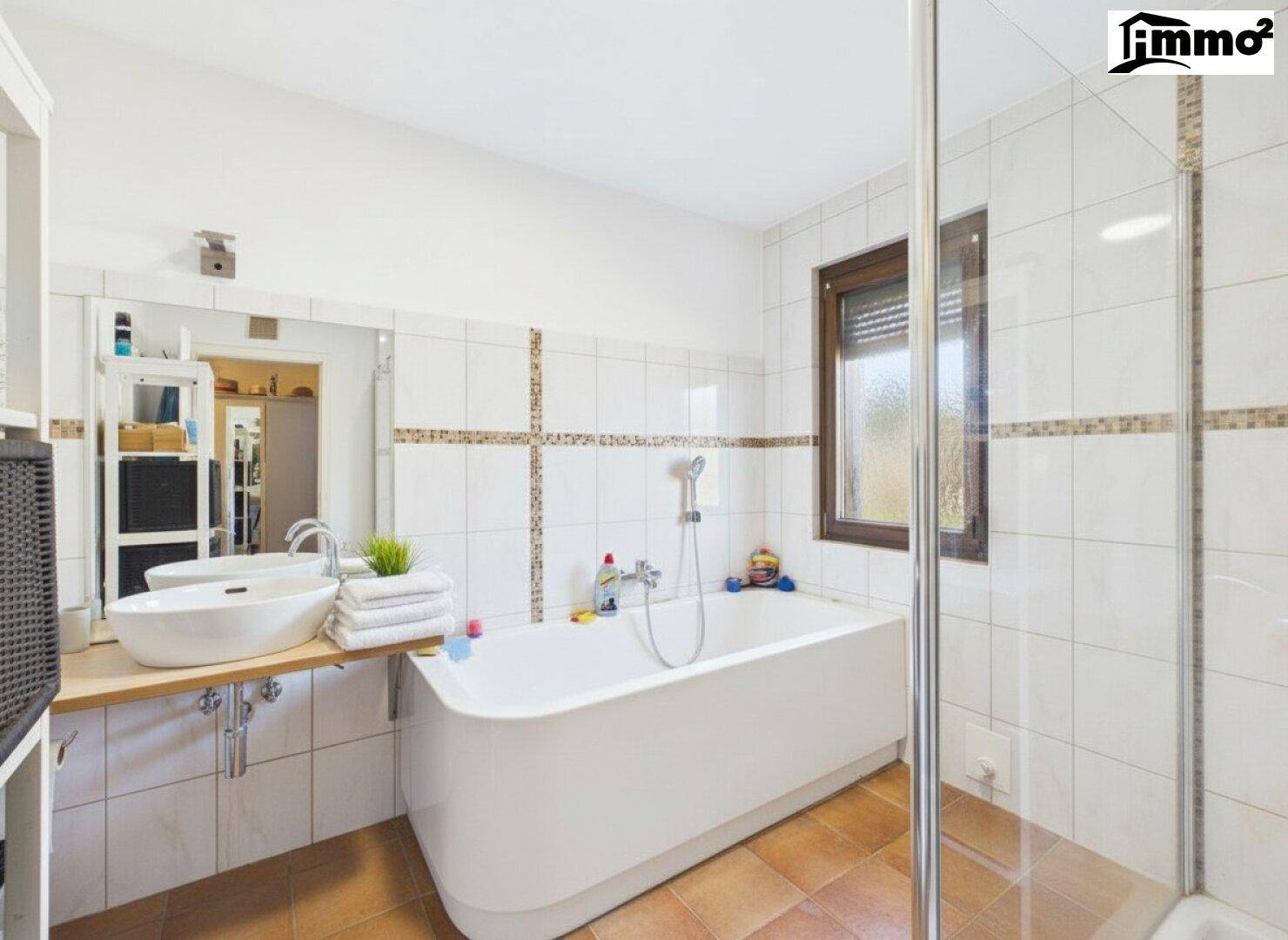 Modernes Badezimmer mit Badewanne, Dusche und Fenster.