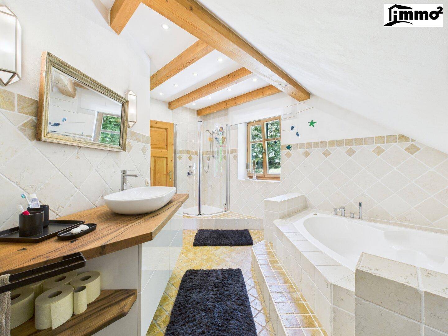 Geräumiges Badezimmer mit Badewanne, Dusche, Holzbalken und Dachschräge.