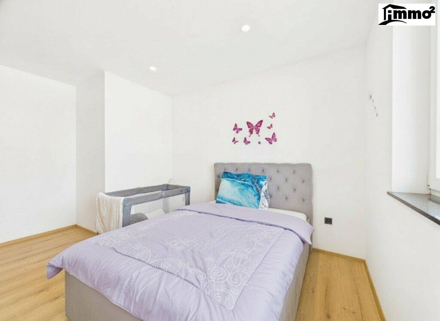 Helles Schlafzimmer mit Einzelbett, Holzboden und verspielter Schmetterlingsdekoration.