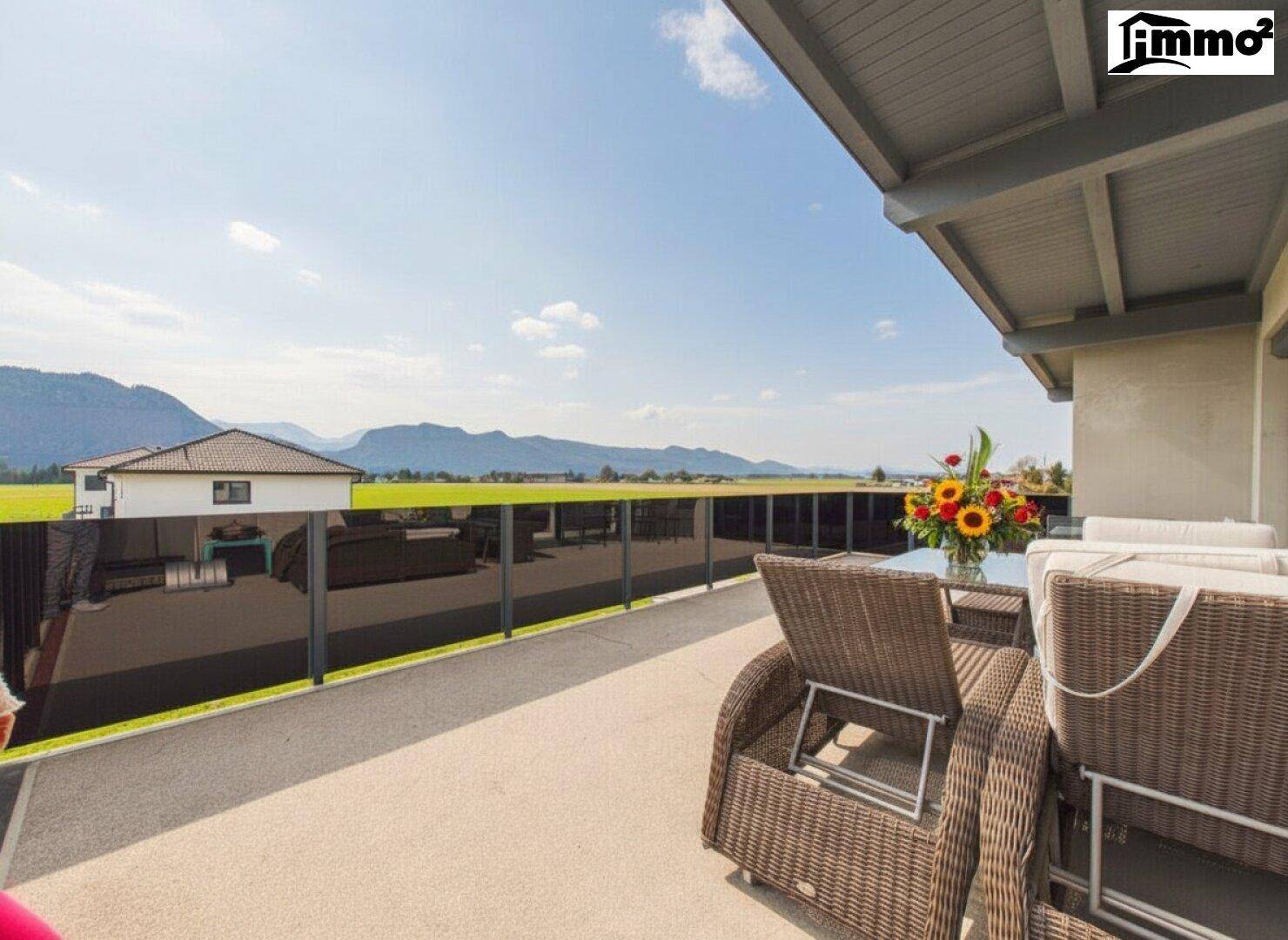 Geräumige Terrasse mit Rattanmöbeln und weitem Blick auf die umliegende Berglandschaft.