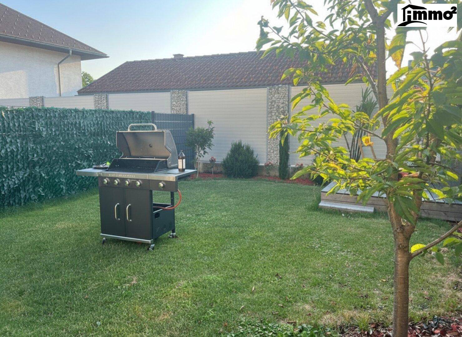 Geräumiger Garten mit Rasenfläche und einem modernen Gasgrill für gesellige Abende.