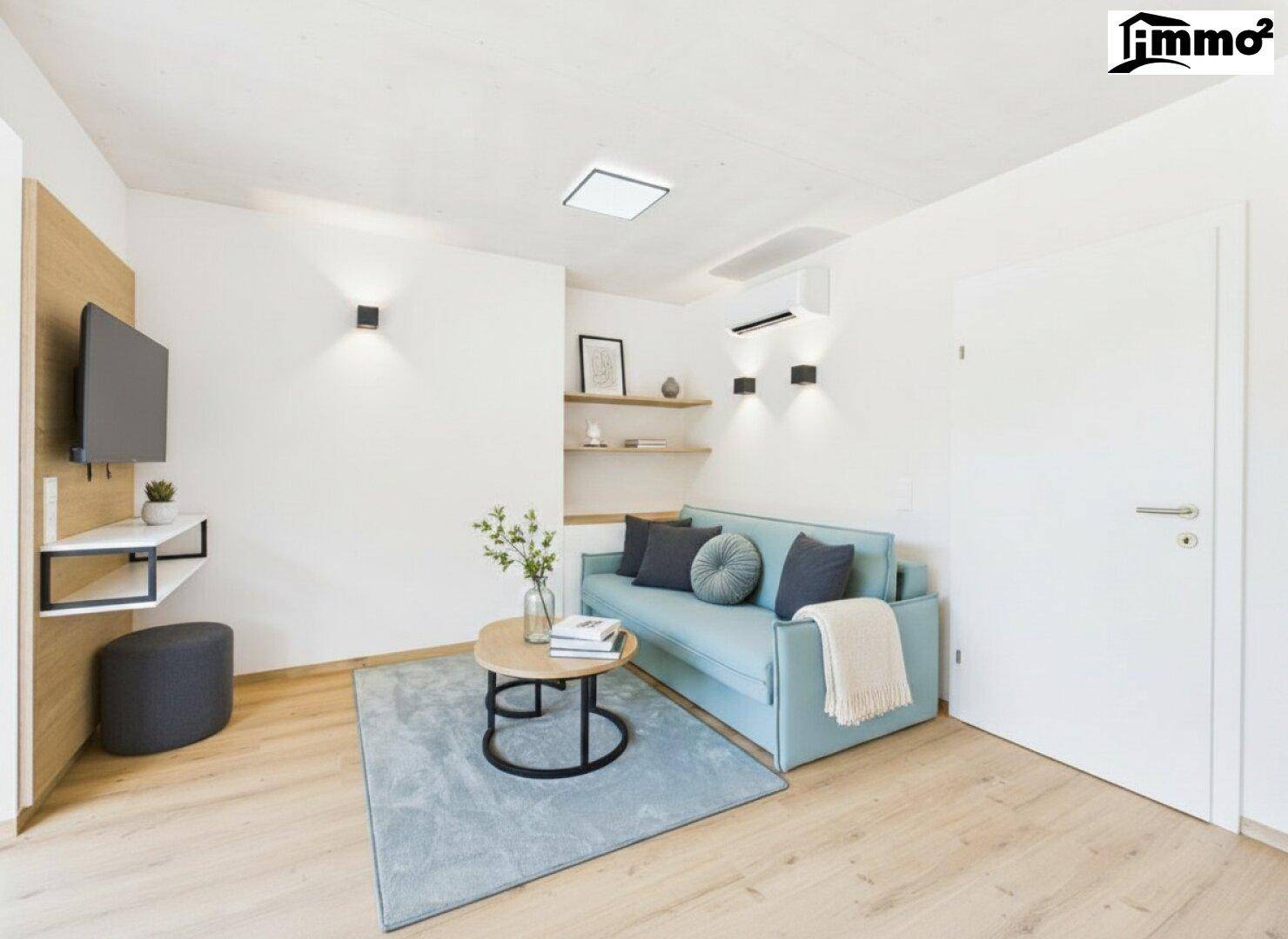 Gemütliches Wohnzimmer mit hellblauem Sofa, modernem TV-Bereich und Holzboden.
