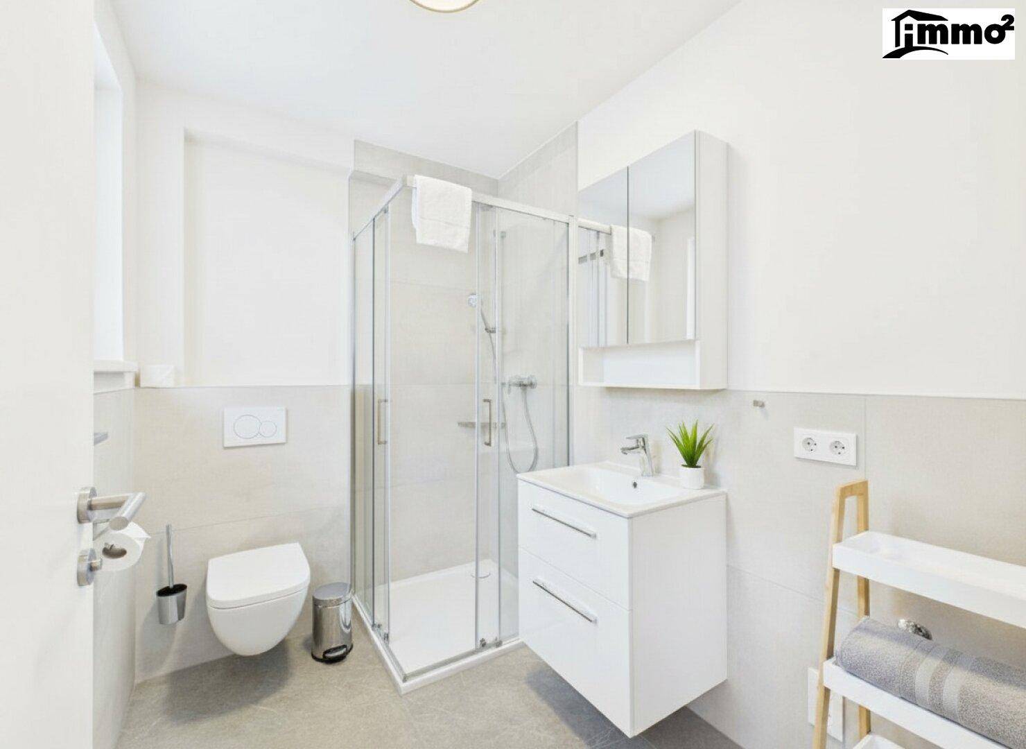 Modernes Badezimmer mit Duschkabine, wandhängendem WC und hellem Fliesenboden.