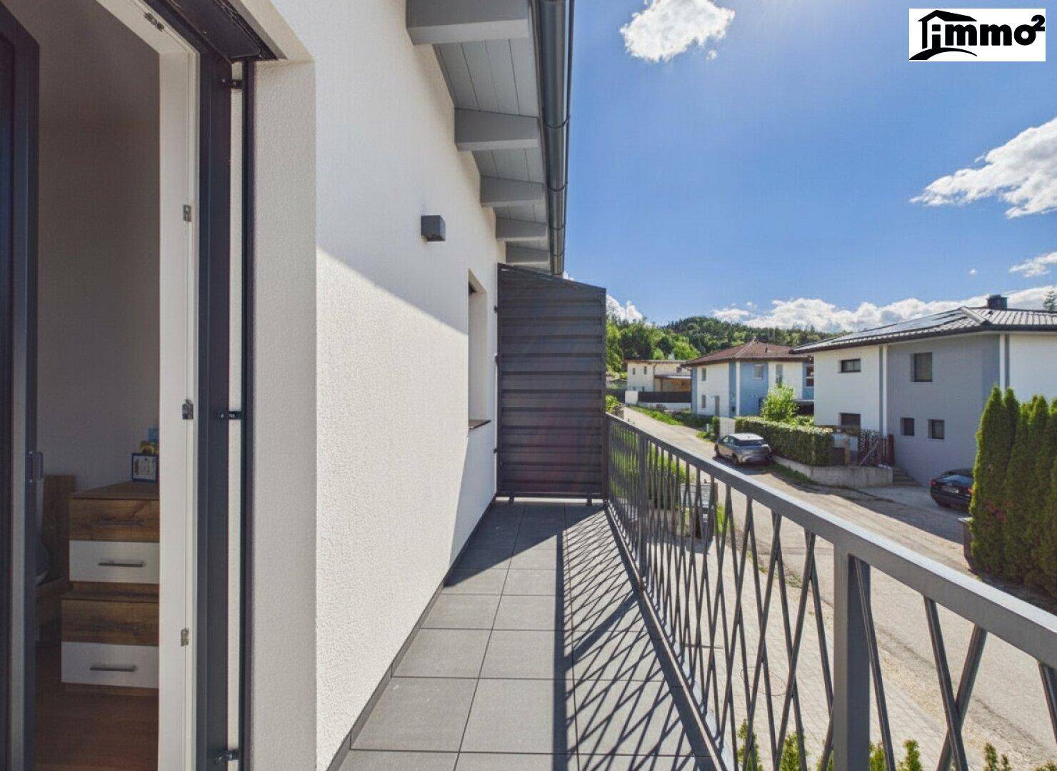 Langer Balkon mit Fliesenboden und Blick auf die umliegende Nachbarschaft.