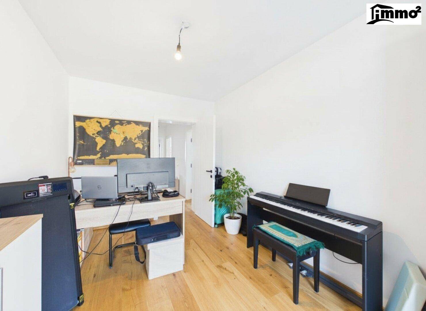 Geräumiges Arbeitszimmer mit Holzboden, Schreibtisch und einem digitalen Klavier.