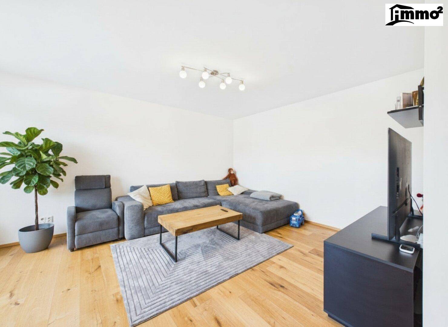 Geräumiges Wohnzimmer mit großem Ecksofa, Holzboden und modernem Couchtisch.