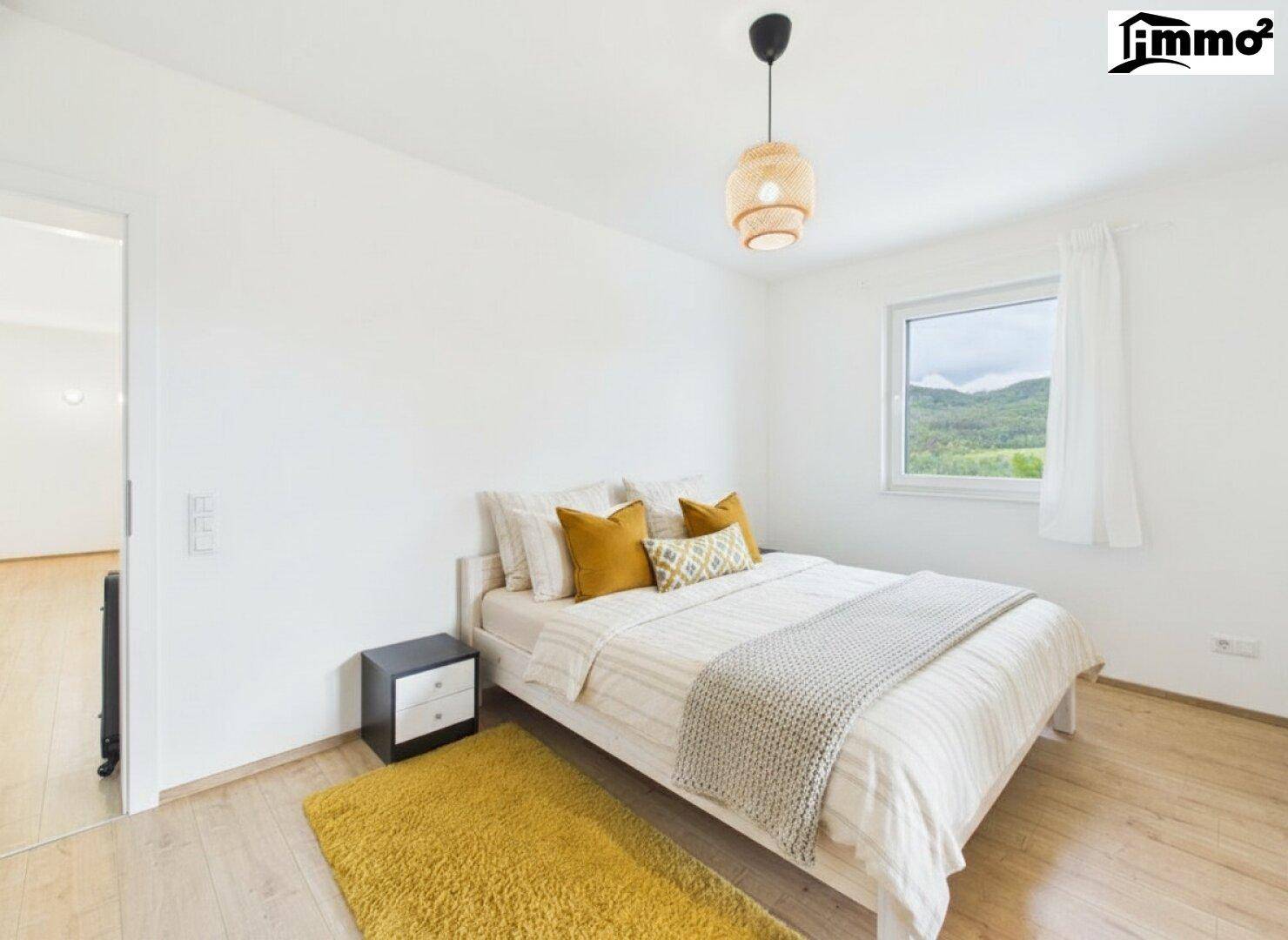 Gemütliches Schlafzimmer mit Holzboden, Doppelbett und Fenster mit Bergblick.