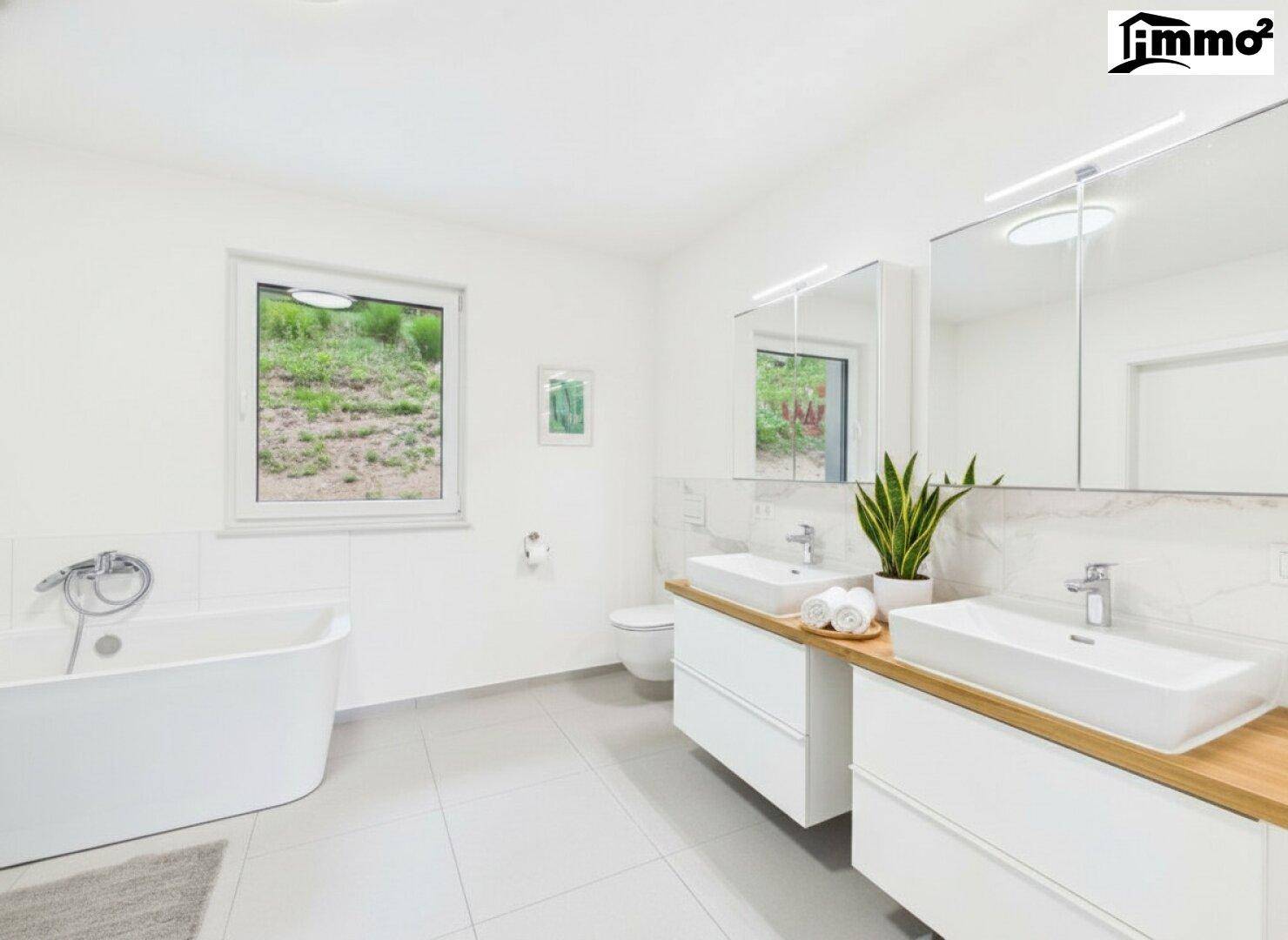 Geräumiges Badezimmer mit Doppelwaschbecken, Badewanne und Fenster.