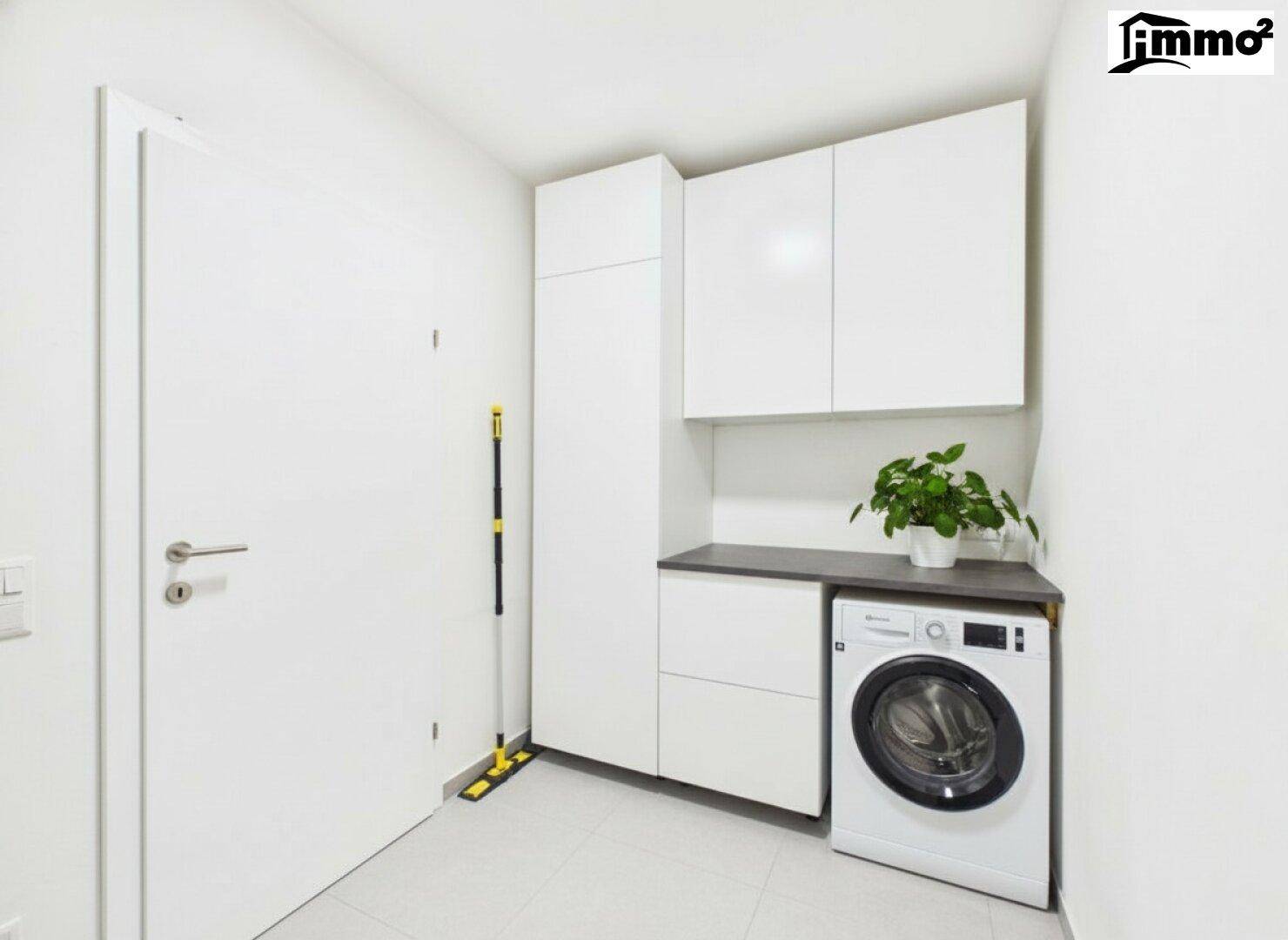 Praktischer Hauswirtschaftsraum mit Waschmaschine, Schränken und Fliesenboden.