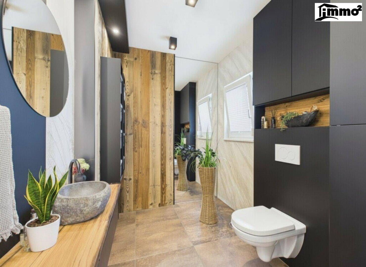 Elegantes Badezimmer mit Steinwaschbecken, Holzvertäfelung und großem Spiegel.