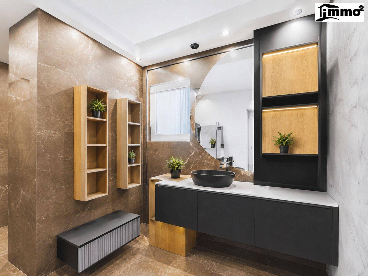 Luxuriöses Badezimmer mit dunklen Schränken, schwarzem Waschbecken und indirekter Beleuchtung.