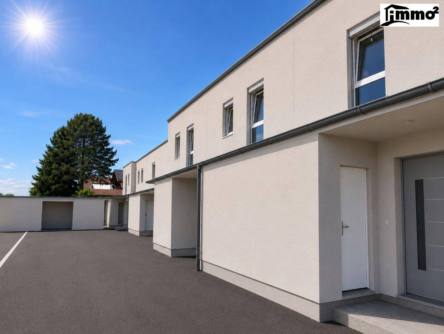 Moderne Reihenhäuser mit Zufahrt und Parkplätzen, umgeben von Grünflächen.