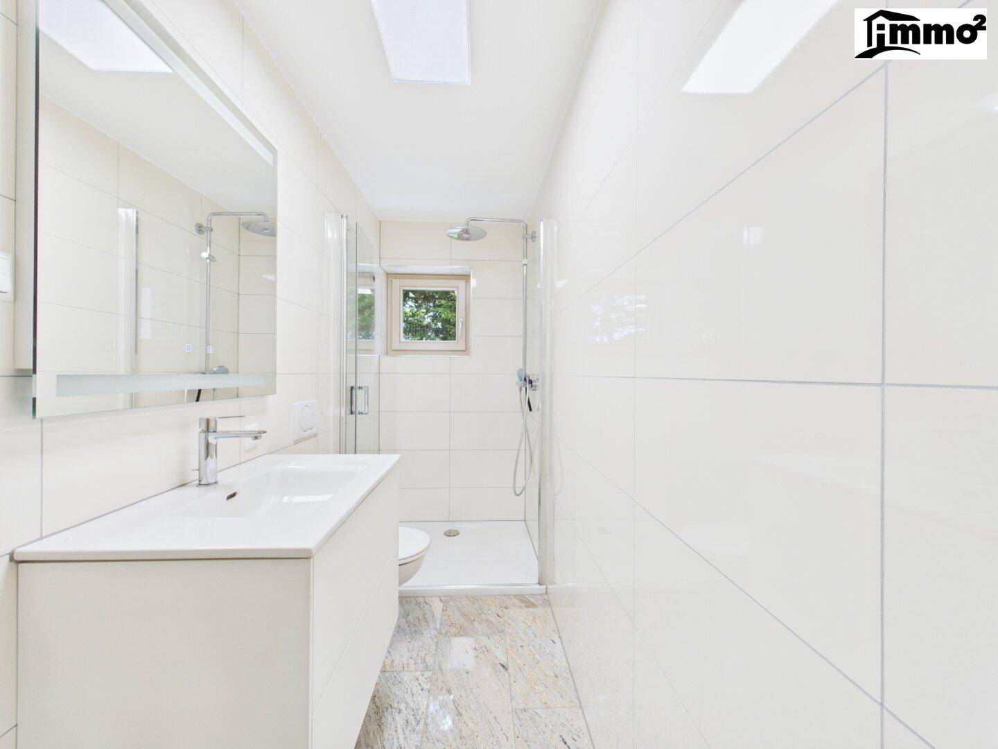 Modernes Badezimmer mit großer Dusche, Einzelwaschbecken und Fenster für Tageslicht und gute Belüftung.
