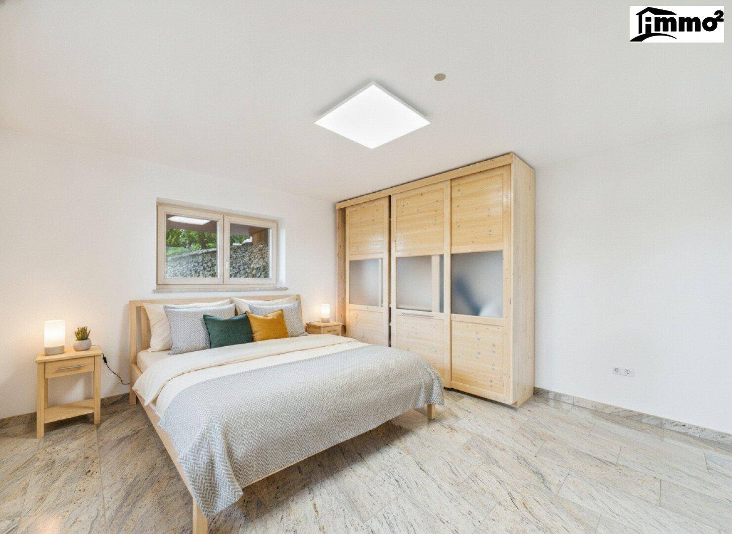 Gemütliches Schlafzimmer mit Holzbett, Schiebetürenschrank und hellem Fliesenboden.