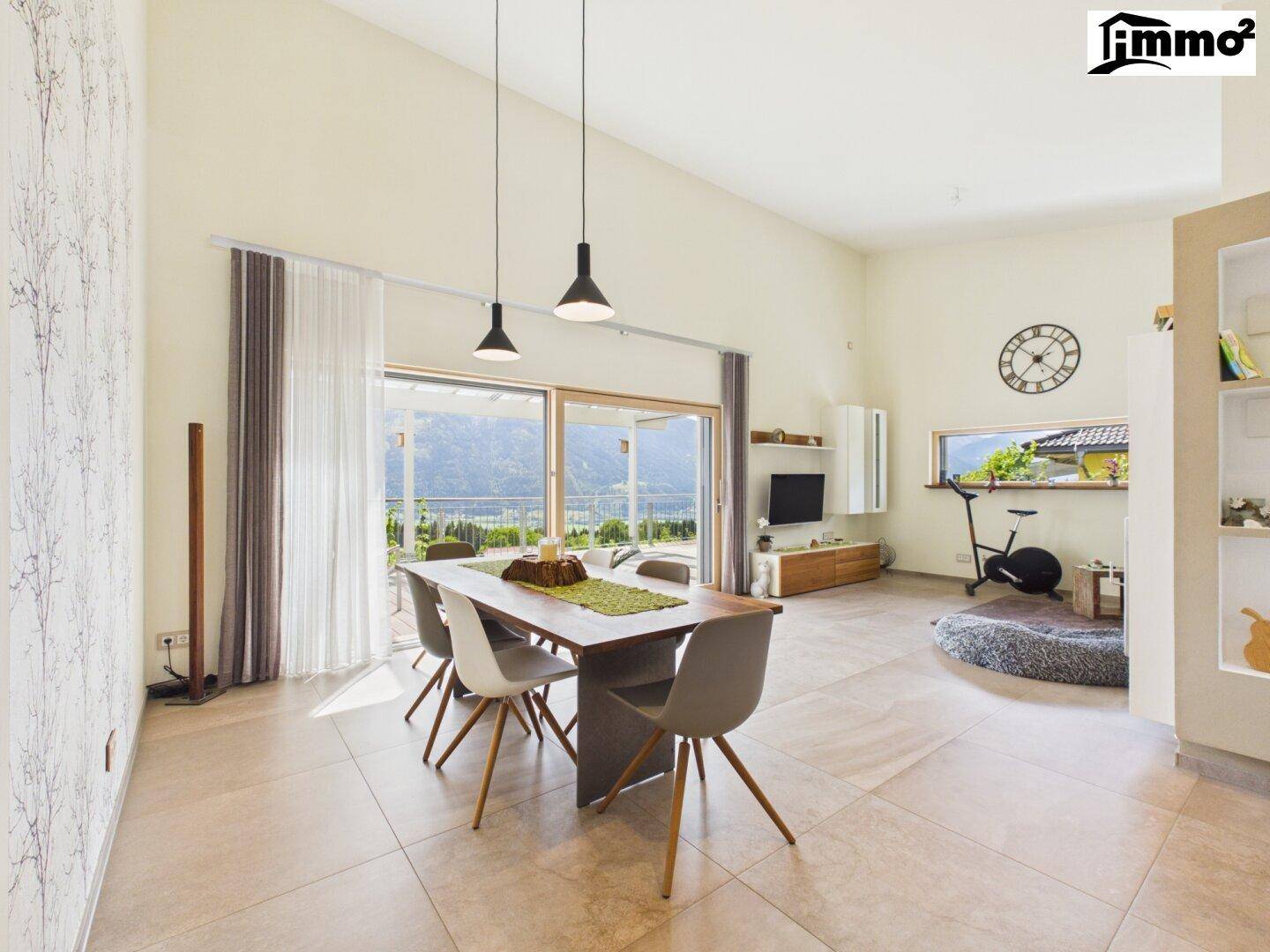 Geräumiger Wohn- und Essbereich mit hohen Decken, großen Fenstern und modernem Interieur.