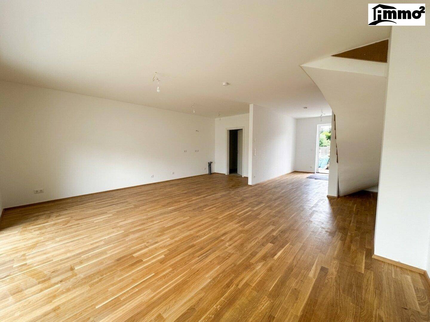 Weitläufiger Wohnbereich mit Parkettboden und viel Tageslicht, bereit zur Einrichtung.