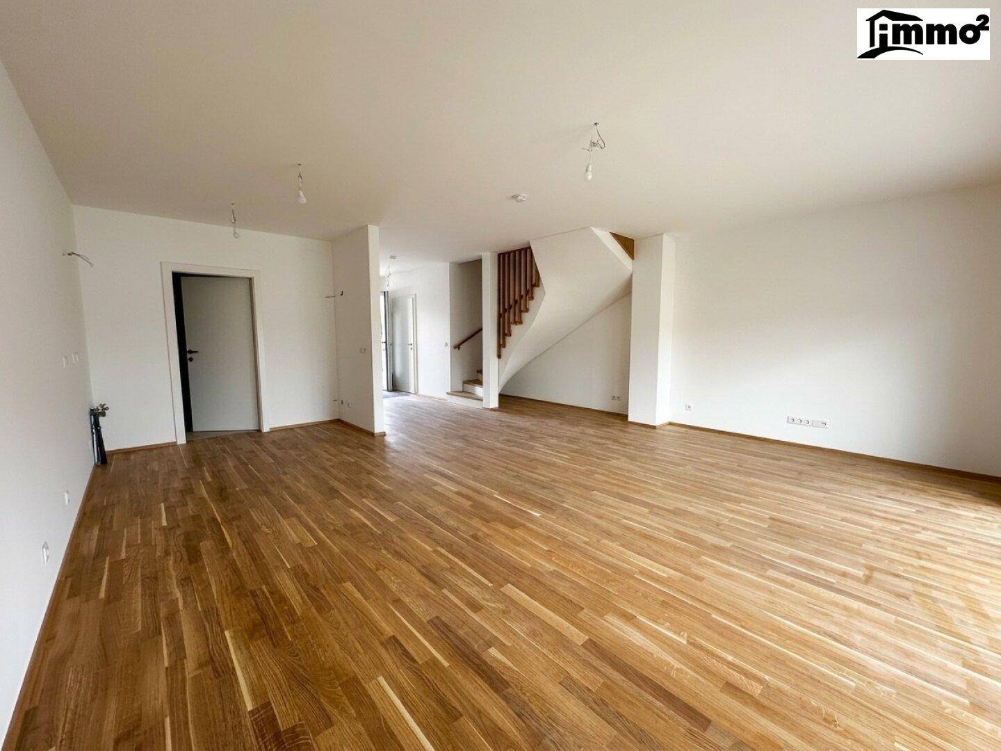 Großzügiger Wohnbereich mit Parkettboden und Zugang zur Treppe, ideal für offenes Wohnen.