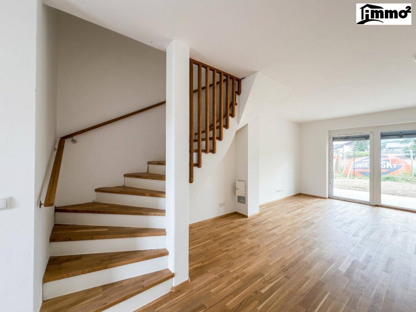 Heller Wohnbereich mit Holztreppe und Parkettboden, bereit für individuelle Gestaltung.
