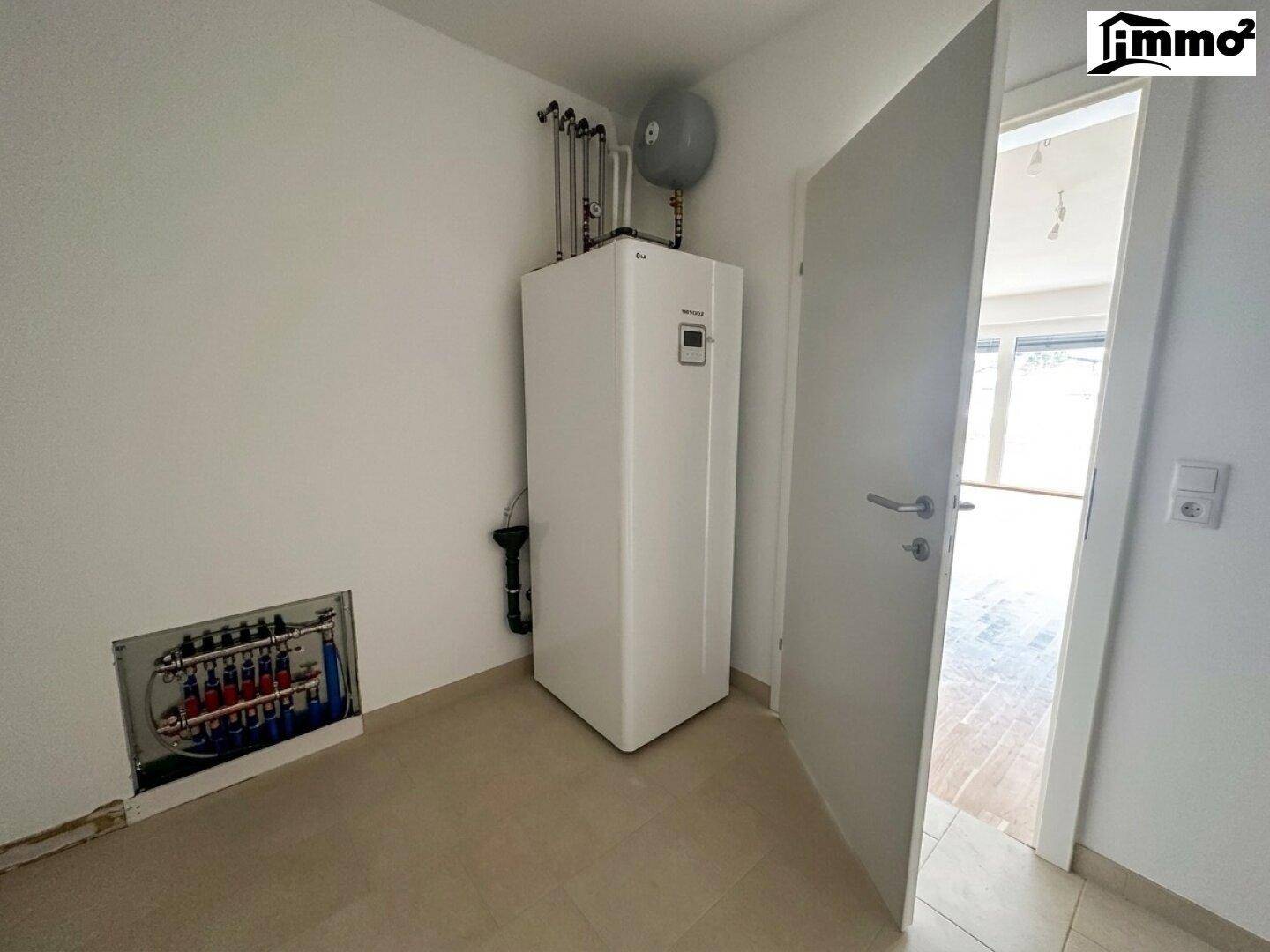 Technikraum mit moderner Wärmepumpe und Verteiler für die Fußbodenheizung.