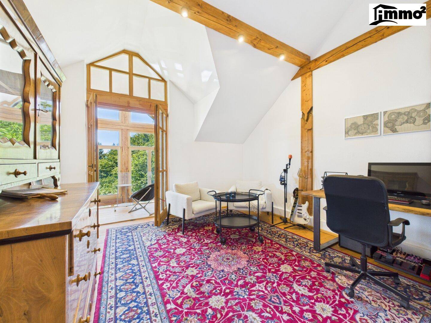 Geräumiges Arbeitszimmer mit Holzboden, hohen Decken und Zugang zu einem Balkon.