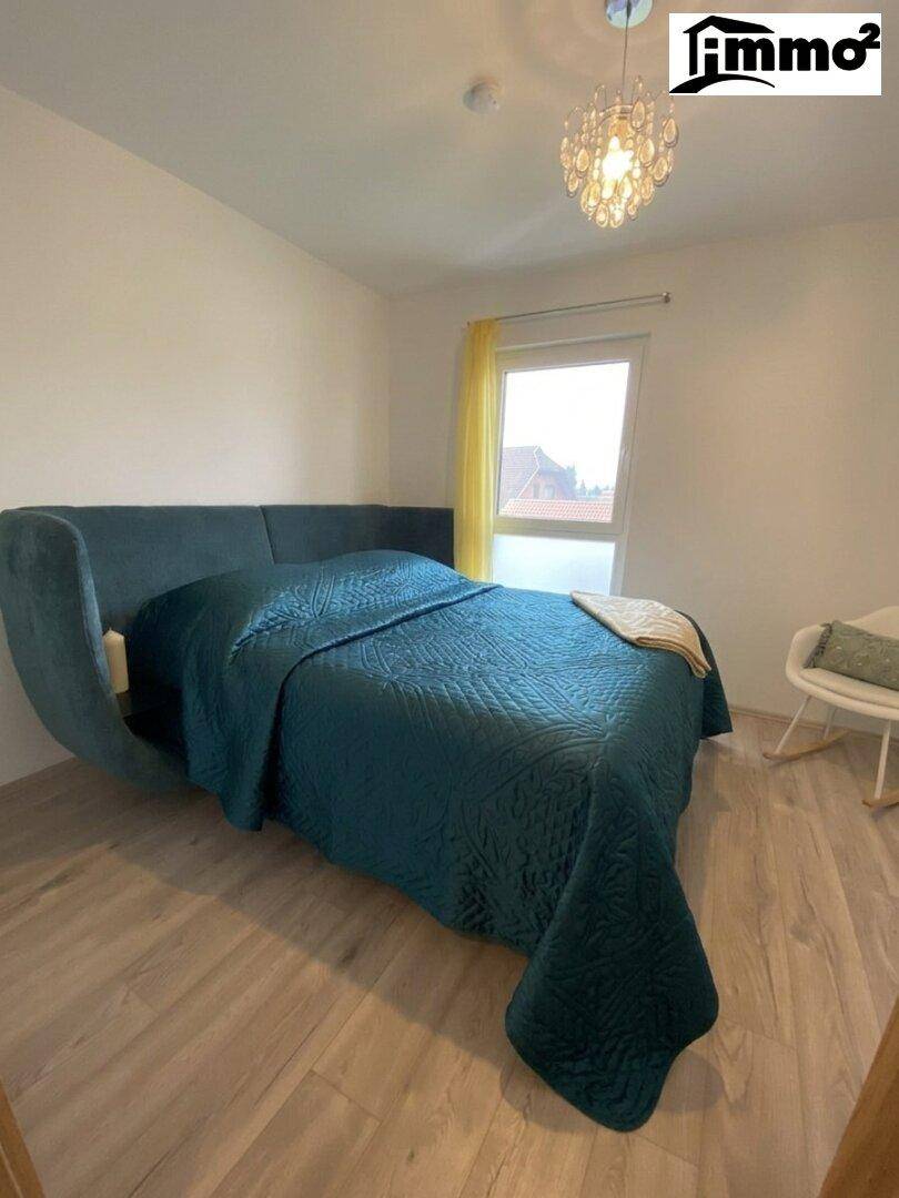 Schlafzimmer mit einem großen, bequemen Bett und einem Fenster, das viel Licht hereinlässt.