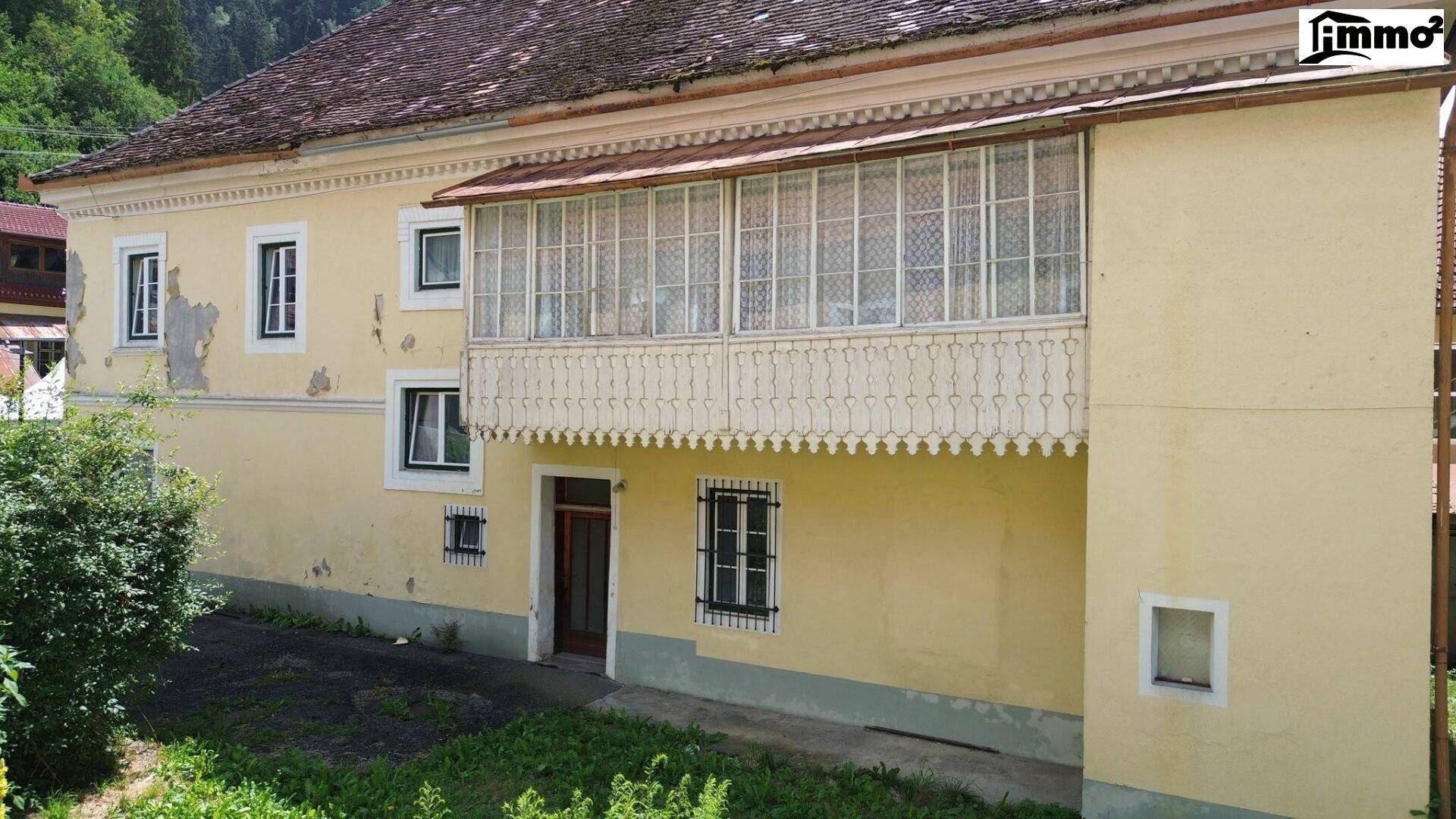 Seitenansicht des Gebäudes mit einem charmanten, verglasten Balkon oder Loggia.